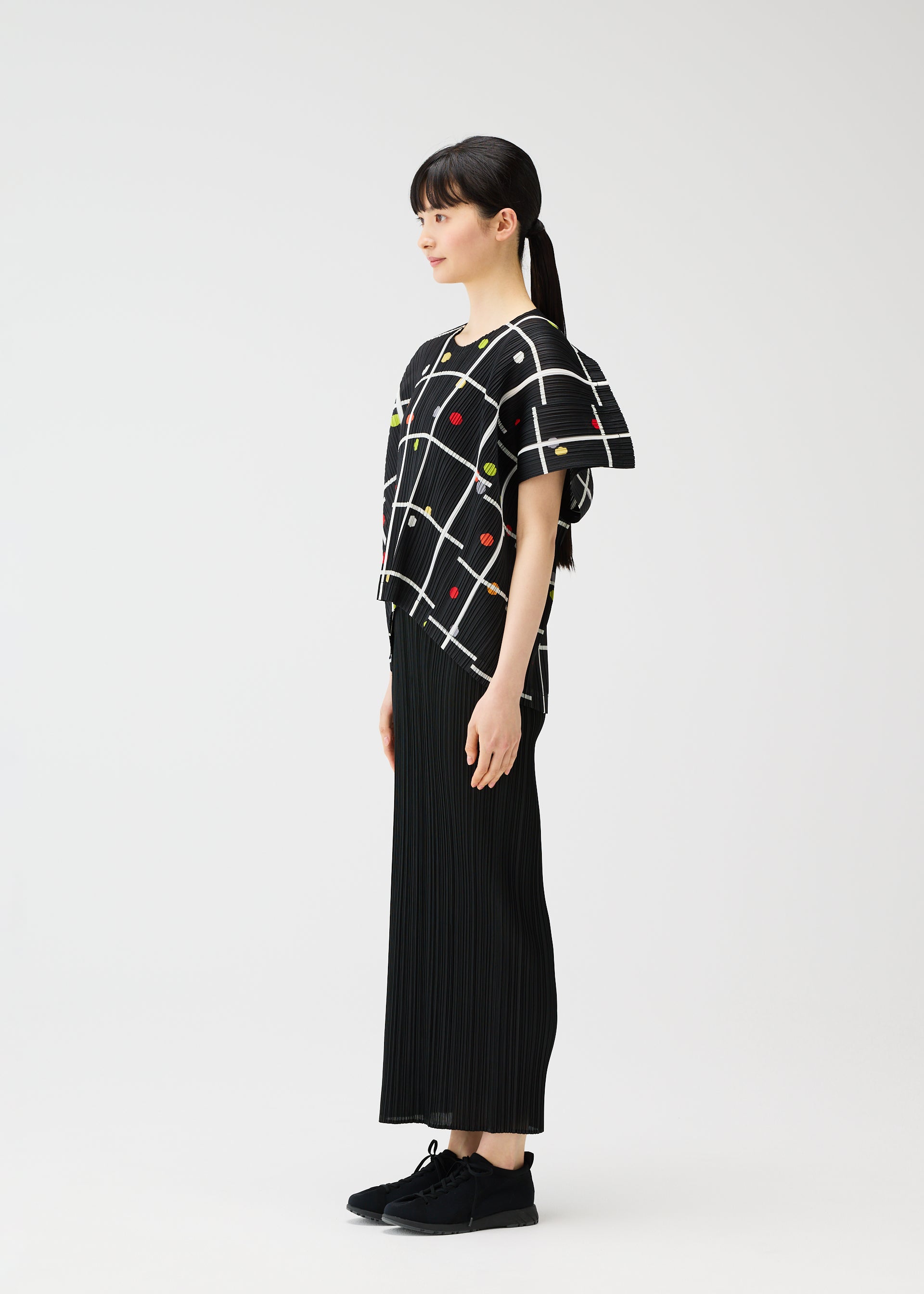 A model wears the PLEATS PLEASE ISSEY MIYAKE CROSSING DOTS shirt.