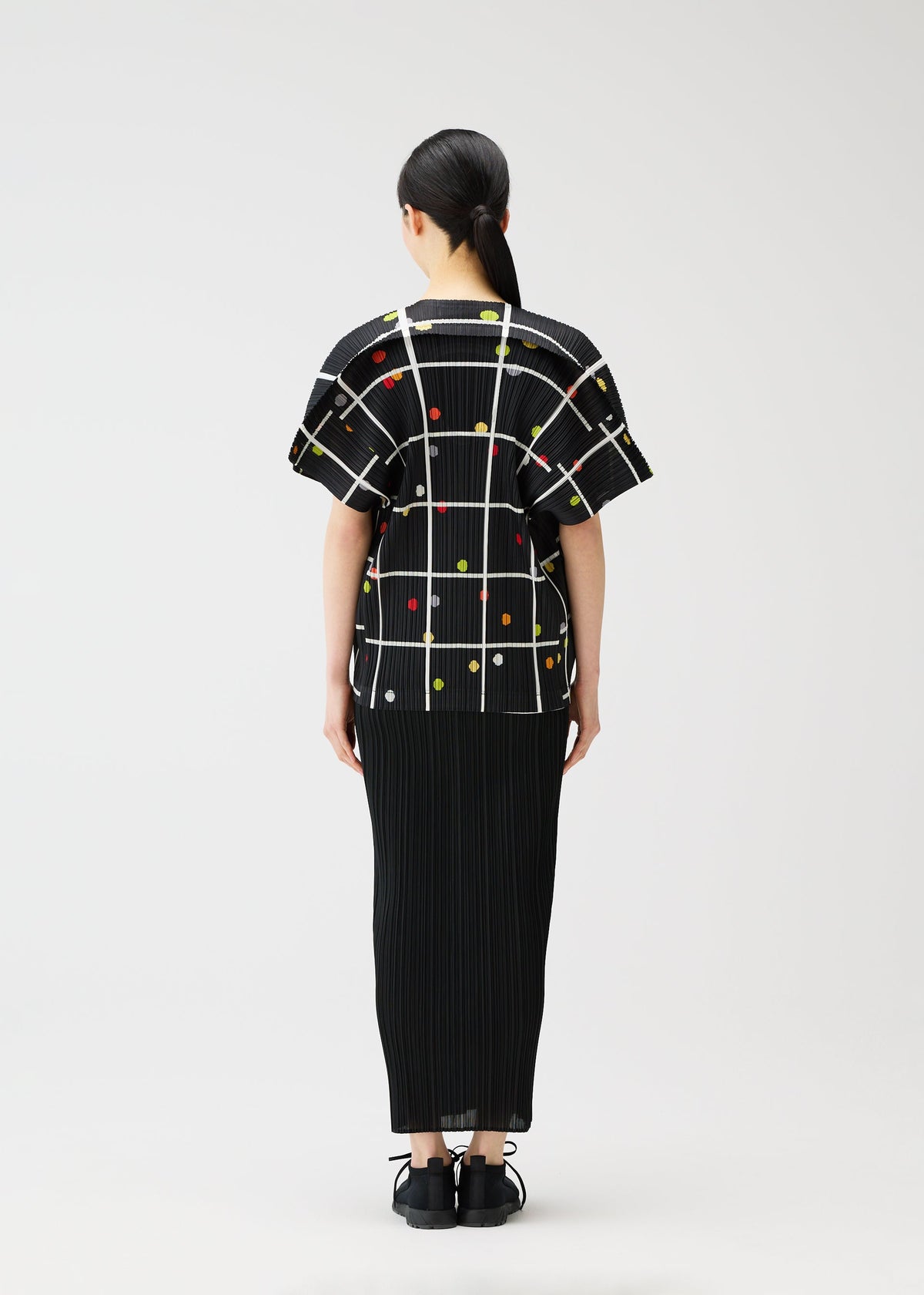 A model wears the PLEATS PLEASE ISSEY MIYAKE CROSSING DOTS shirt.