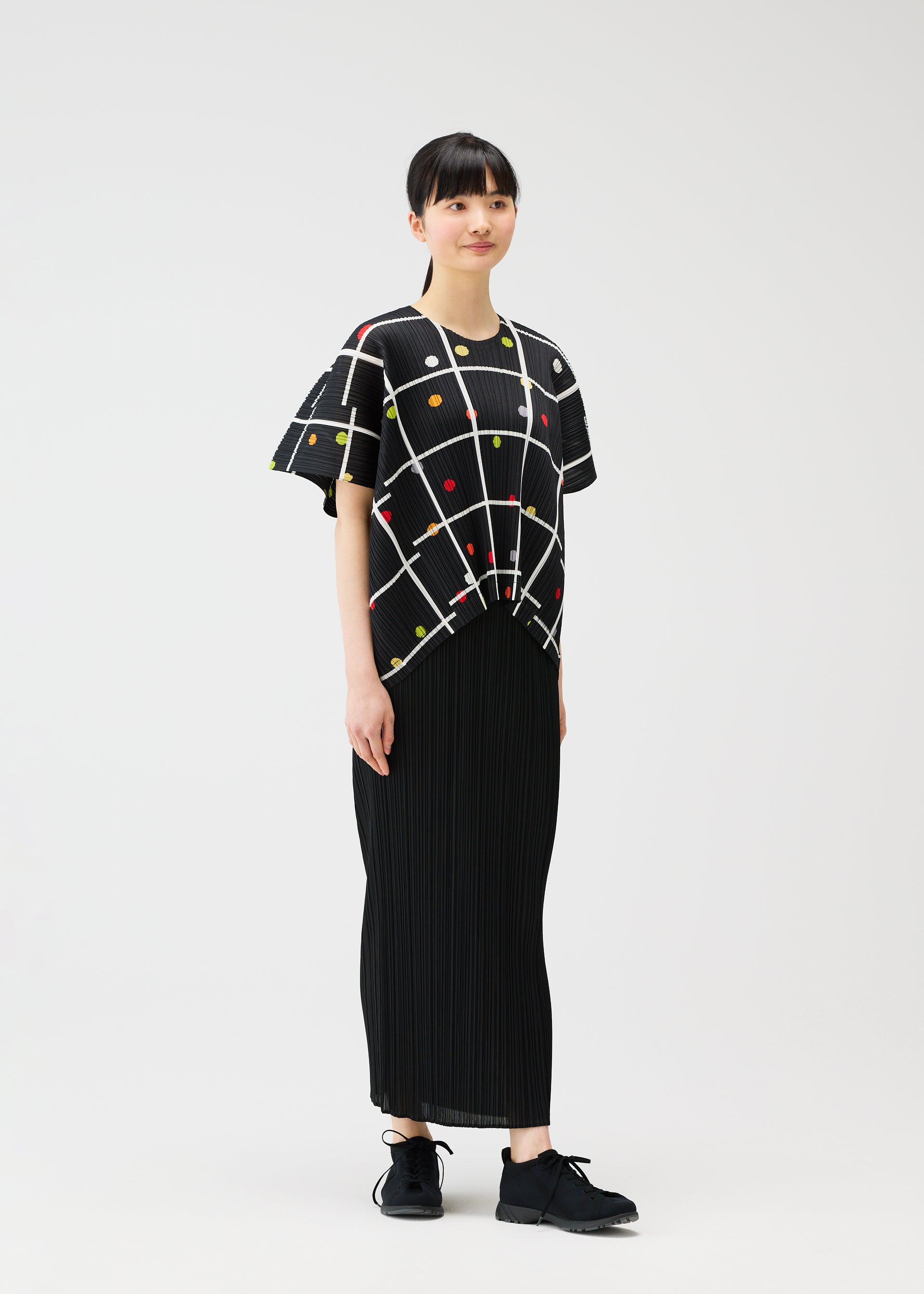 A model wears the PLEATS PLEASE ISSEY MIYAKE CROSSING DOTS shirt.
