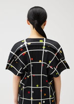 A model wears the PLEATS PLEASE ISSEY MIYAKE CROSSING DOTS shirt.