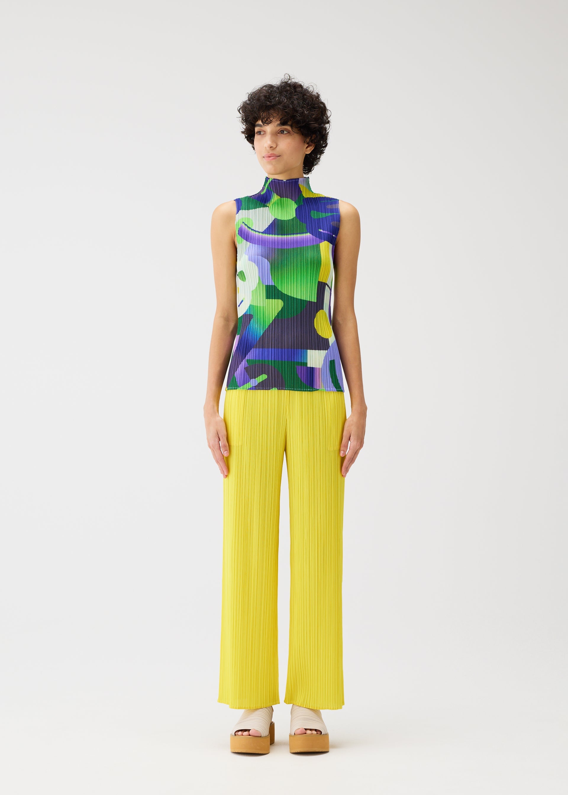A model wears the PLEATS PLEASE ISSEY MIYAKE PLAYGROUND shirt.
