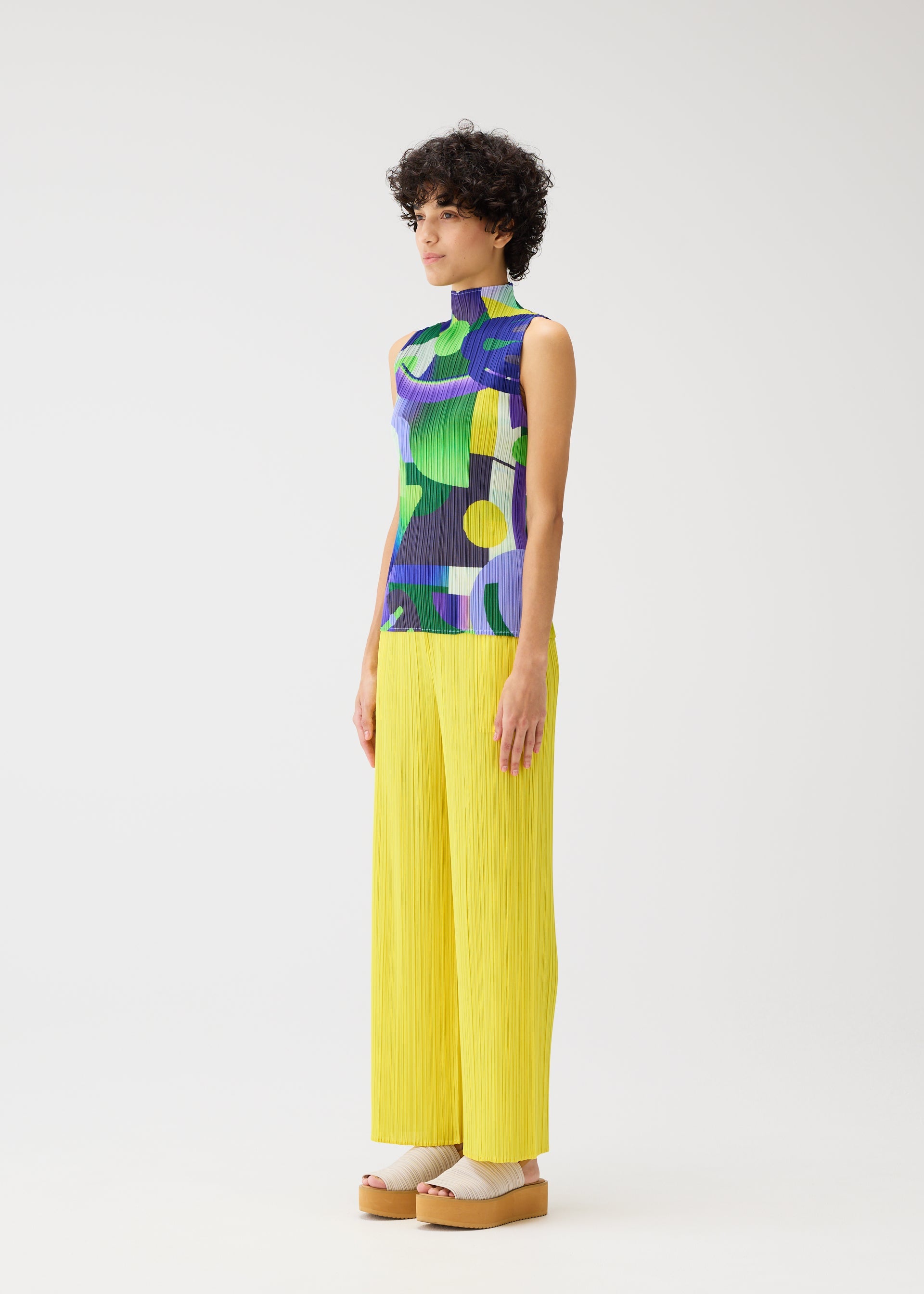 A model wears the PLEATS PLEASE ISSEY MIYAKE PLAYGROUND shirt.
