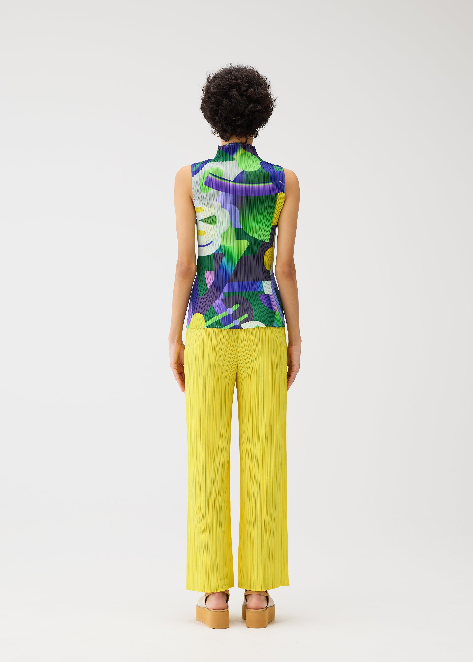 A model wears the PLEATS PLEASE ISSEY MIYAKE PLAYGROUND shirt.