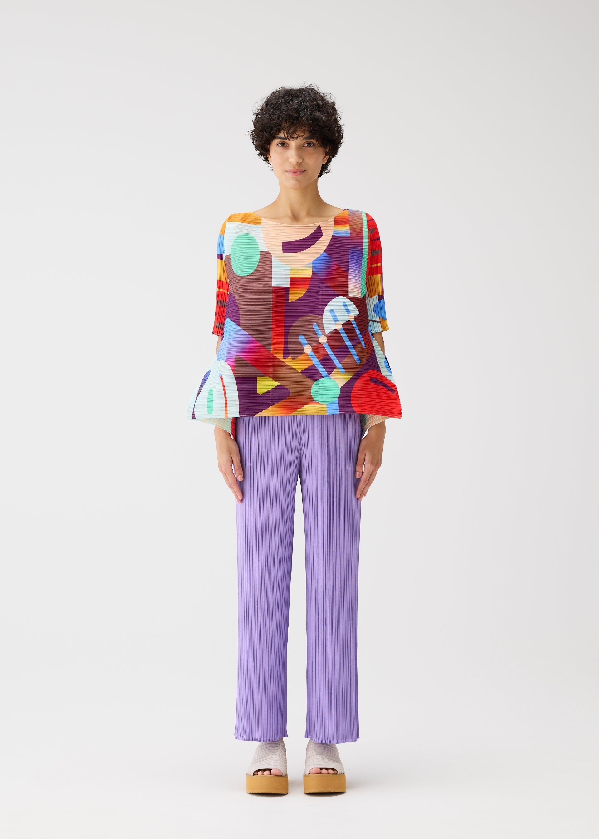A model wears the PLEATS PLEASE ISSEY MIYAKE PLAYGROUND shirt.