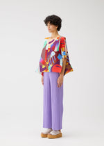 A model wears the PLEATS PLEASE ISSEY MIYAKE PLAYGROUND shirt.