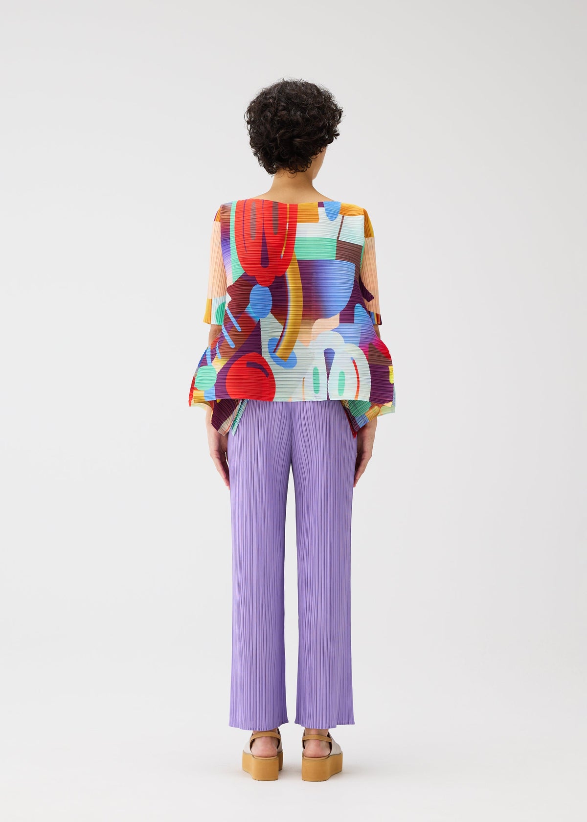 A model wears the PLEATS PLEASE ISSEY MIYAKE PLAYGROUND shirt.