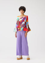 A model wears the PLEATS PLEASE ISSEY MIYAKE PLAYGROUND shirt.
