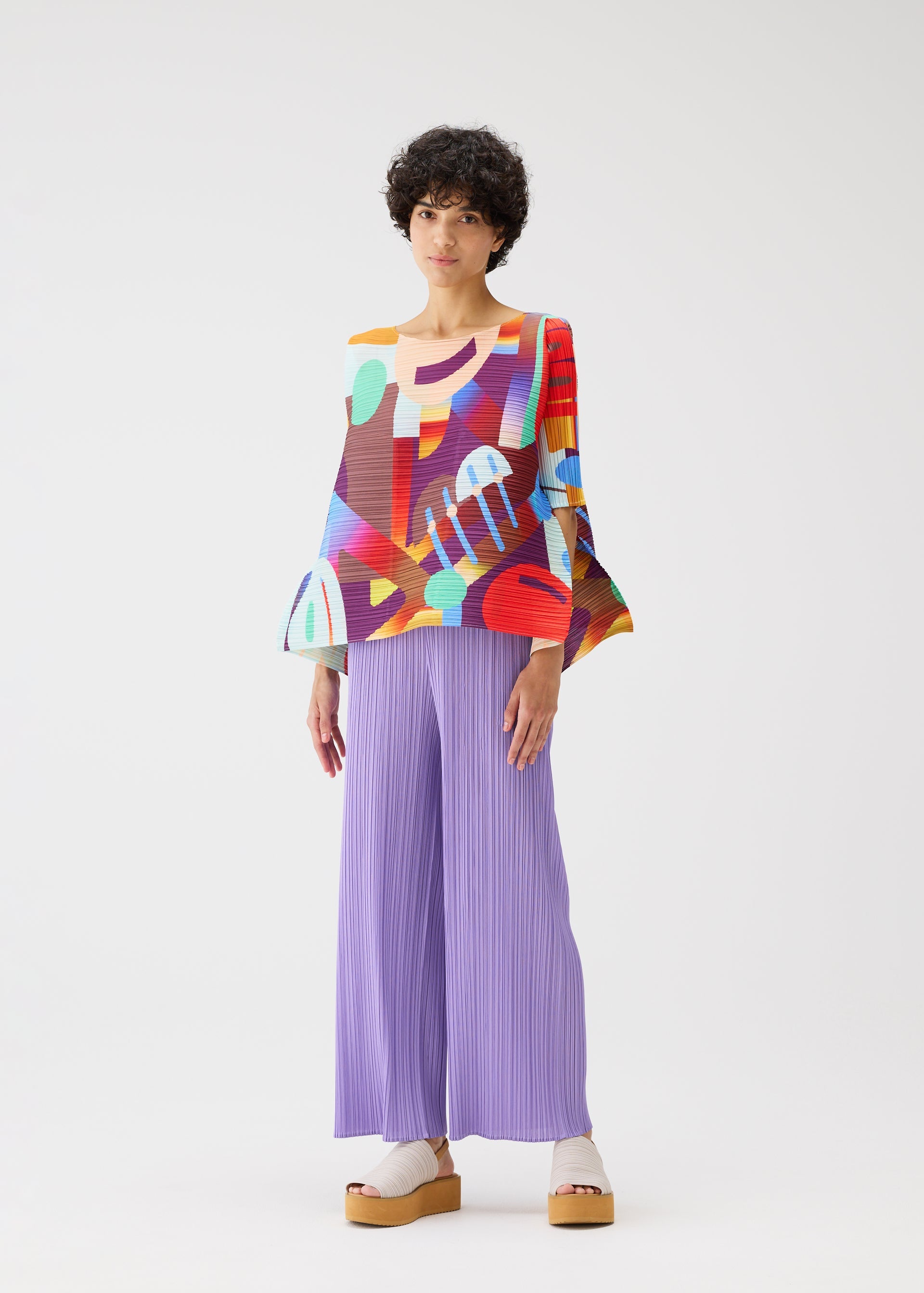 A model wears the PLEATS PLEASE ISSEY MIYAKE PLAYGROUND shirt.