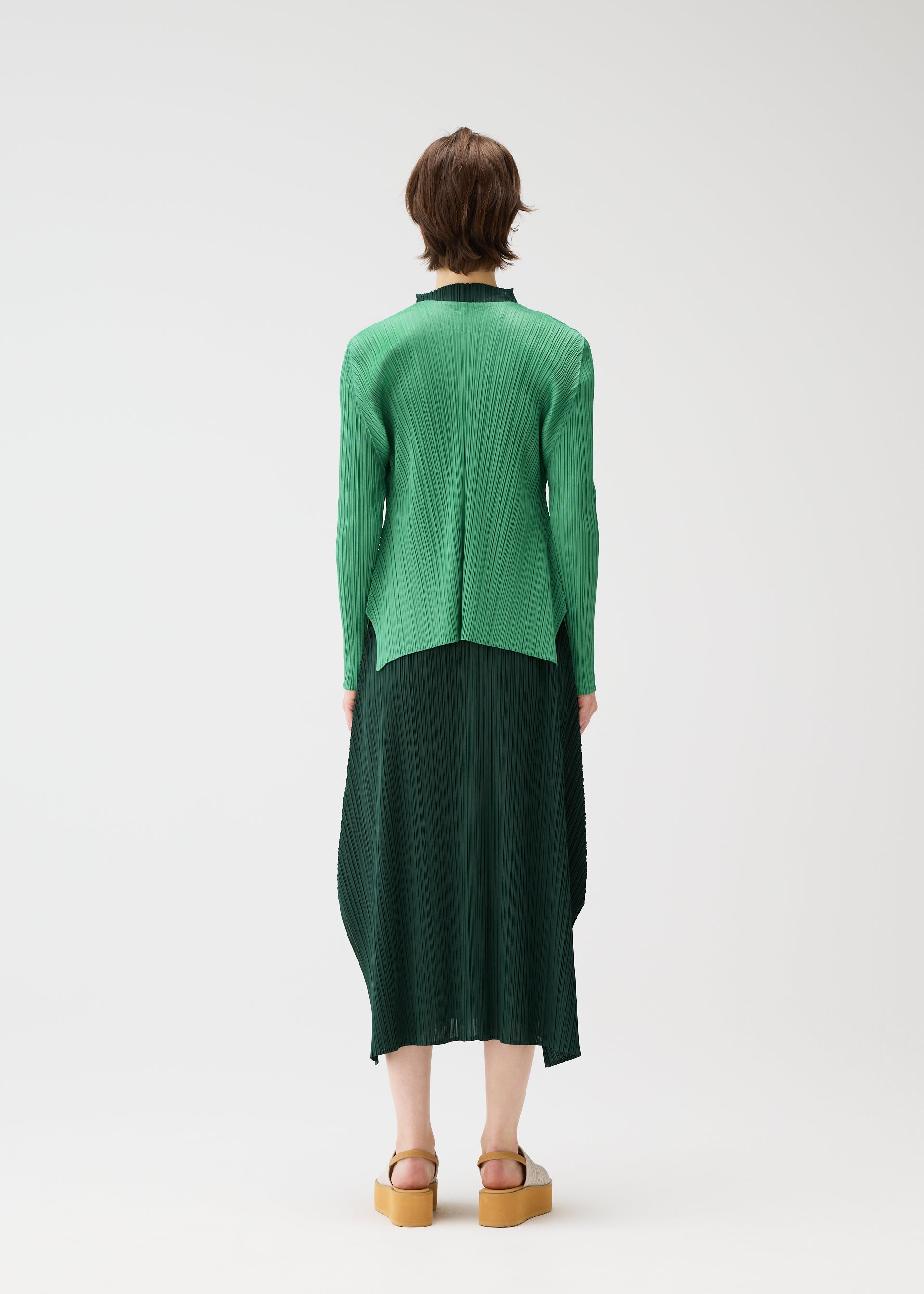 A model wears the PLEATS PLEASE ISSEY MIYAKE MONTHLY COLORS MARCH cardigan.
