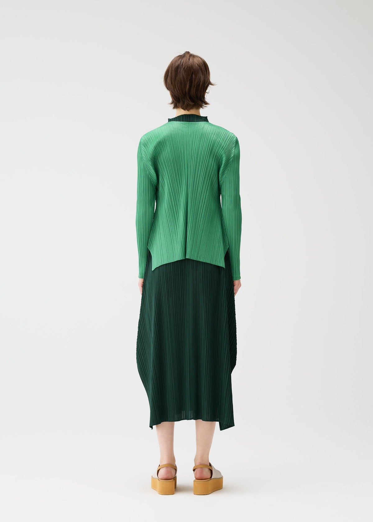 A model wears the PLEATS PLEASE ISSEY MIYAKE MONTHLY COLORS MARCH cardigan.