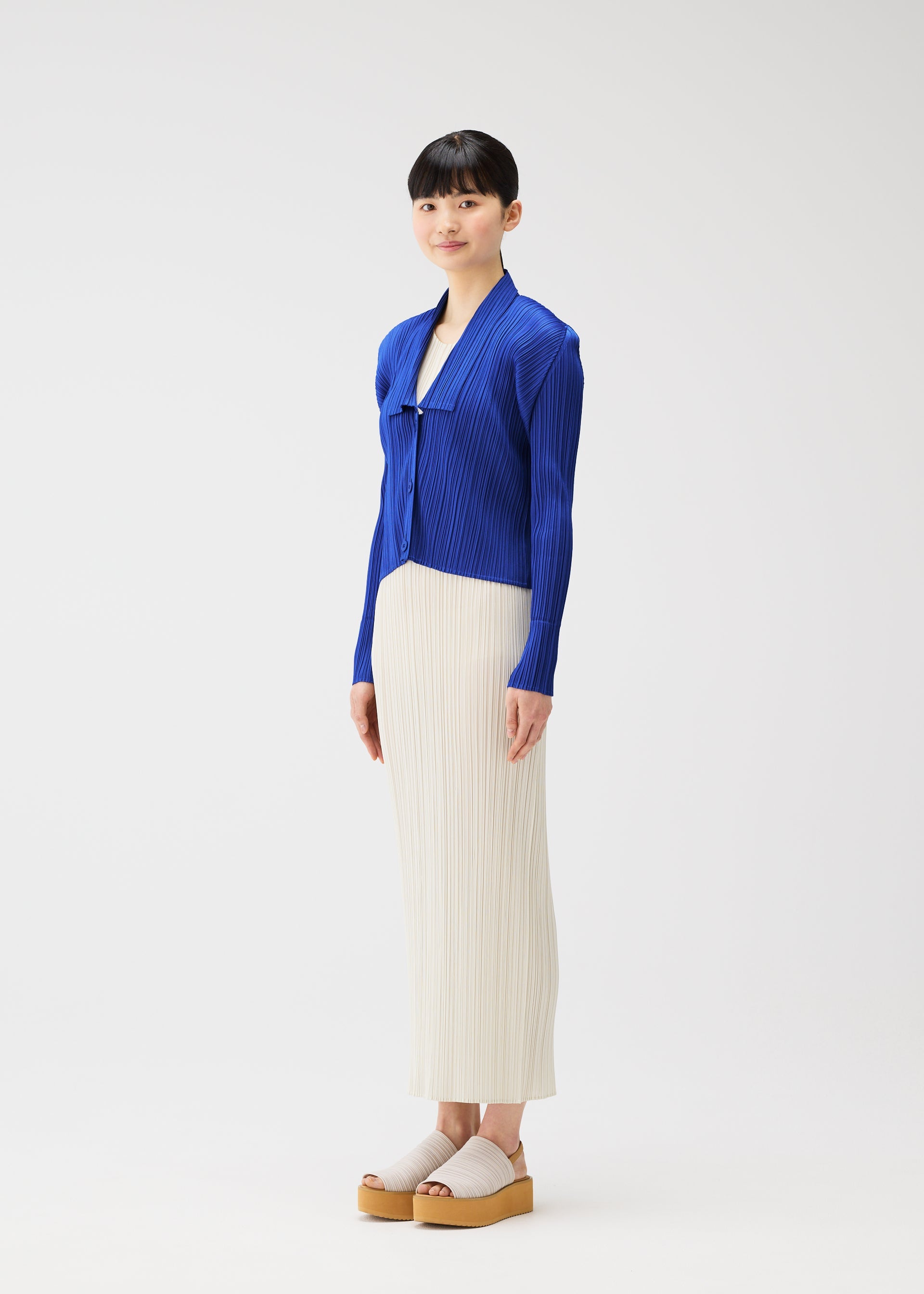 A model wears the PLEATS PLEASE ISSEY MIYAKE MONTHLY COLORS MAY cardigan.