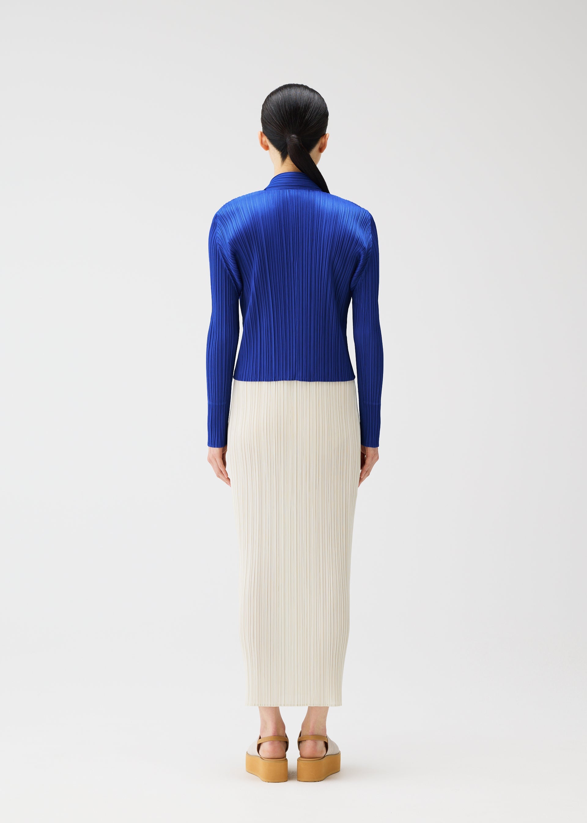 A model wears the PLEATS PLEASE ISSEY MIYAKE MONTHLY COLORS MAY cardigan.