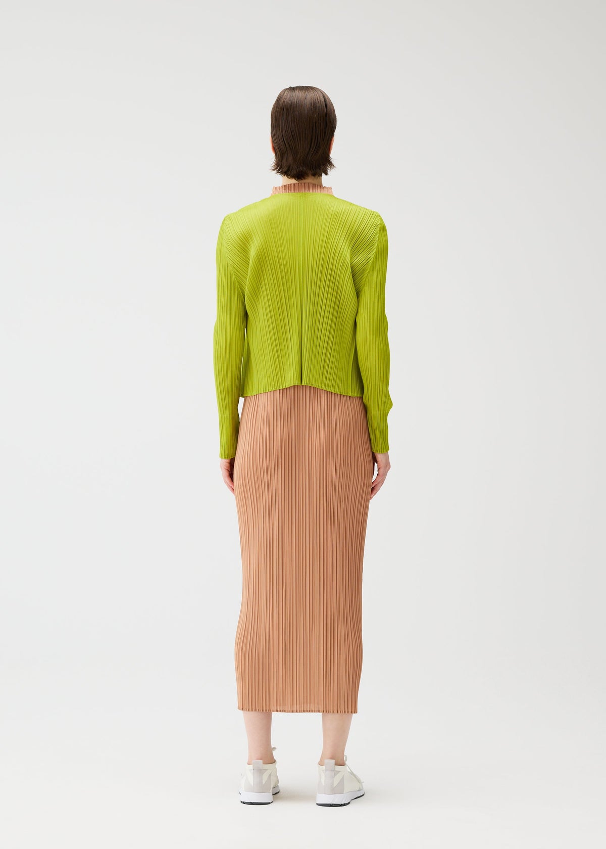 A model wears the PLEATS PLEASE ISSEY MIYAKE MONTHLY COLORS : JUNE monthly-colors-june-cardigan-bright-pink.