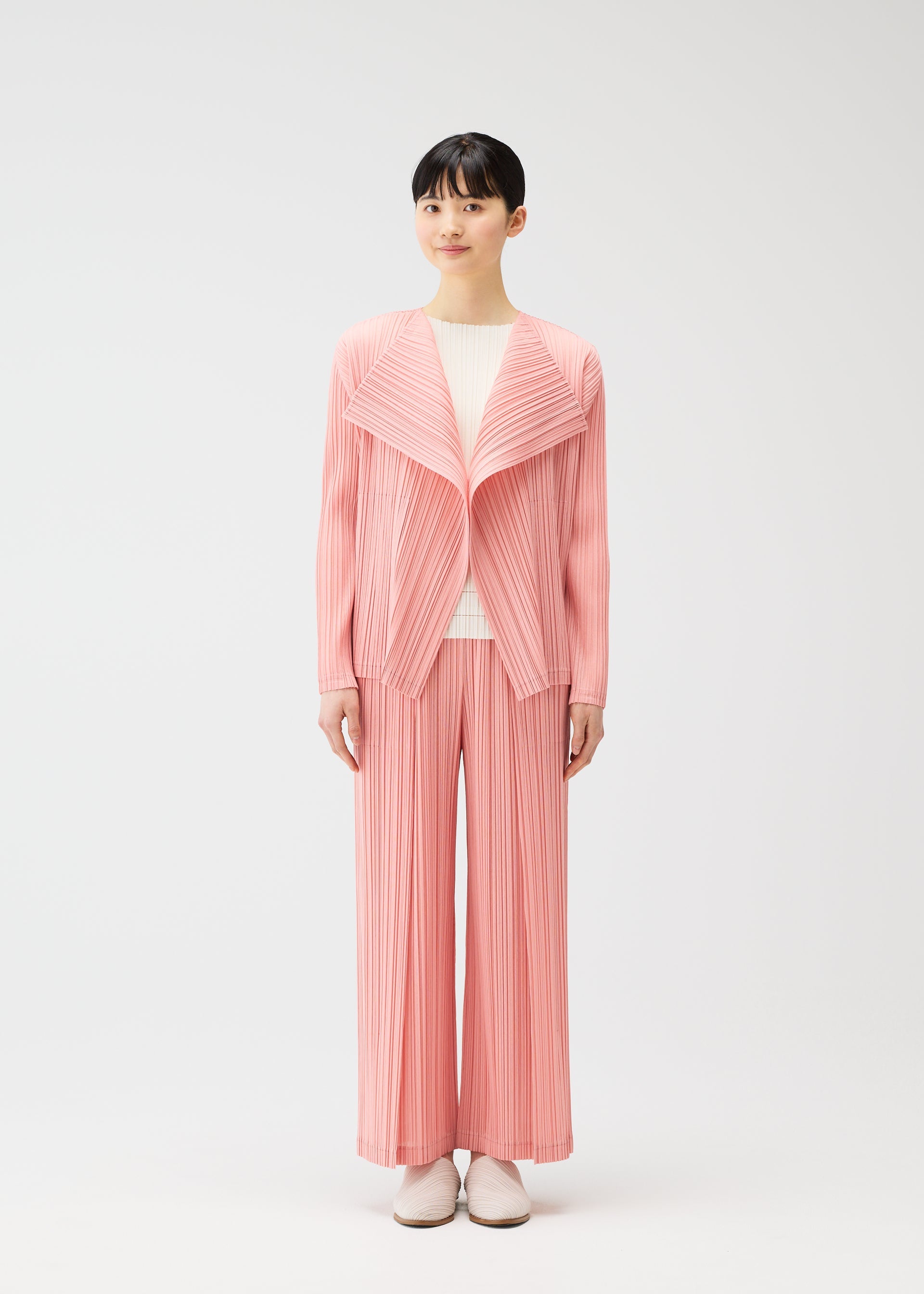 A model wears the PLEATS PLEASE ISSEY MIYAKE RAMIE PLEATS cardigan.