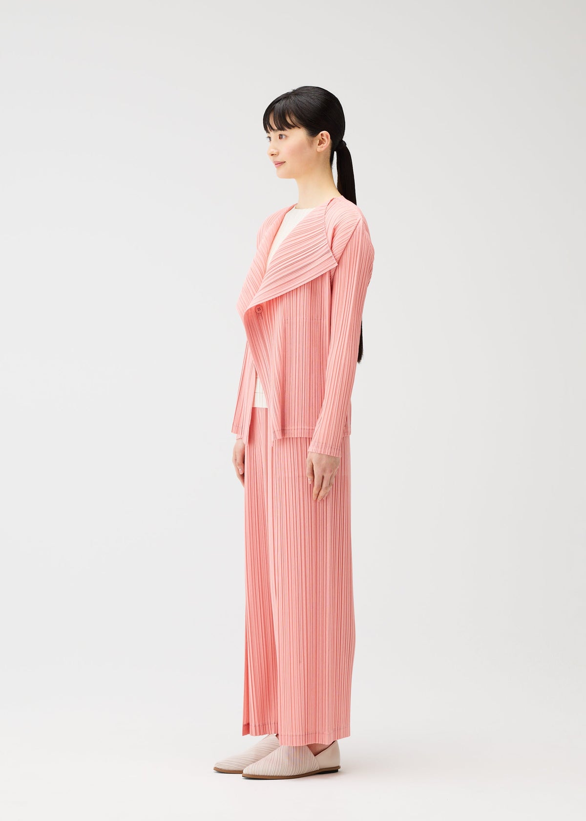 A model wears the PLEATS PLEASE ISSEY MIYAKE RAMIE PLEATS cardigan.
