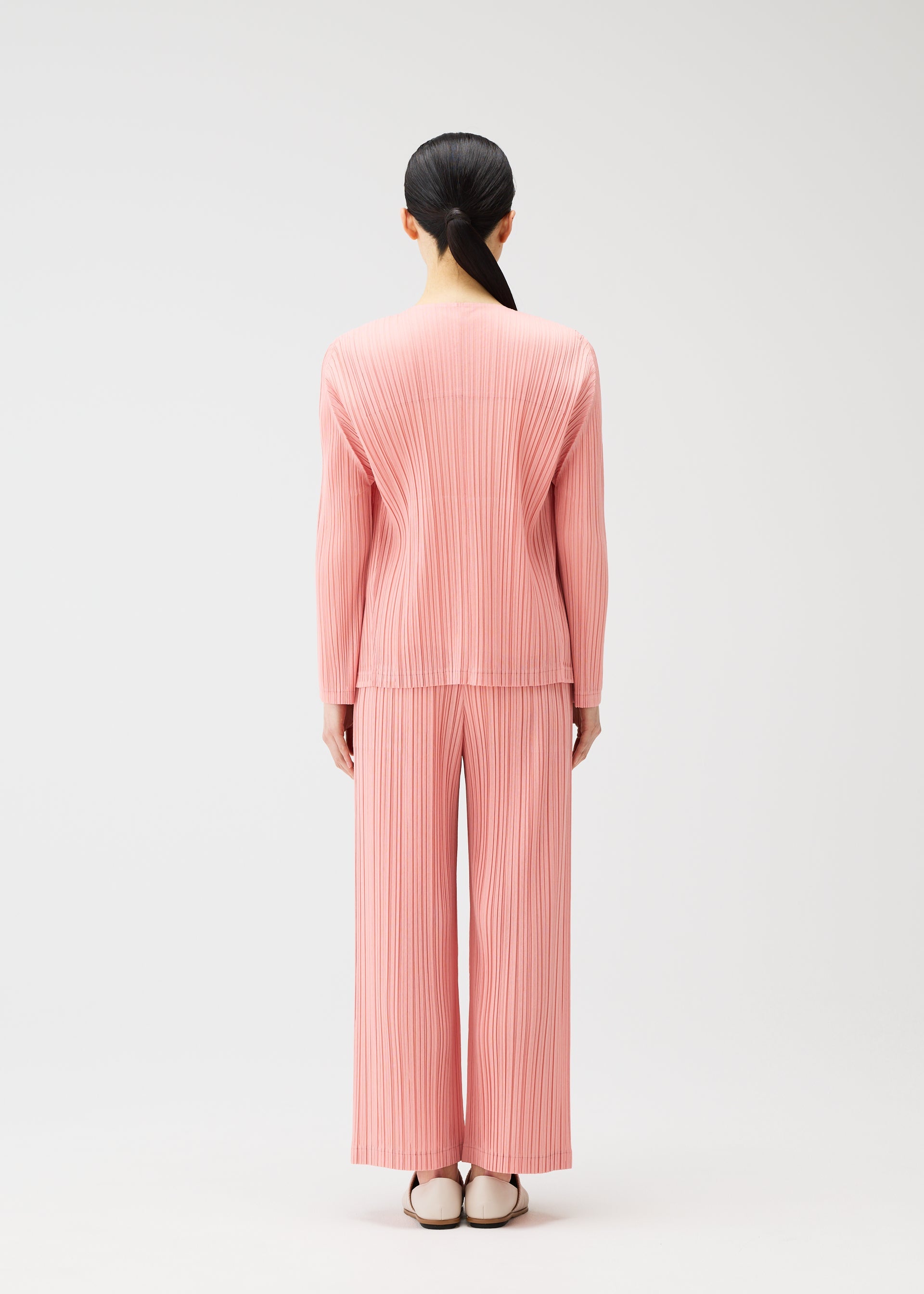 A model wears the PLEATS PLEASE ISSEY MIYAKE RAMIE PLEATS cardigan.