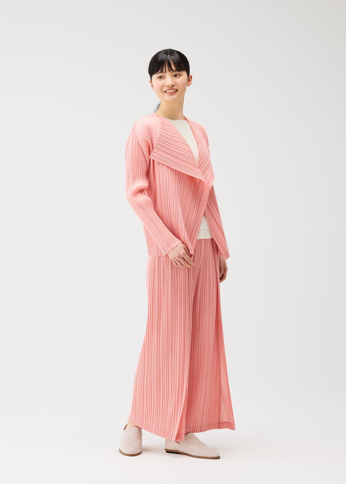 A model wears the PLEATS PLEASE ISSEY MIYAKE RAMIE PLEATS cardigan.