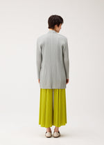 A model wears the PLEATS PLEASE ISSEY MIYAKE MELLOW PLEATS cardigan.
