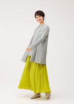 A model wears the PLEATS PLEASE ISSEY MIYAKE MELLOW PLEATS cardigan.