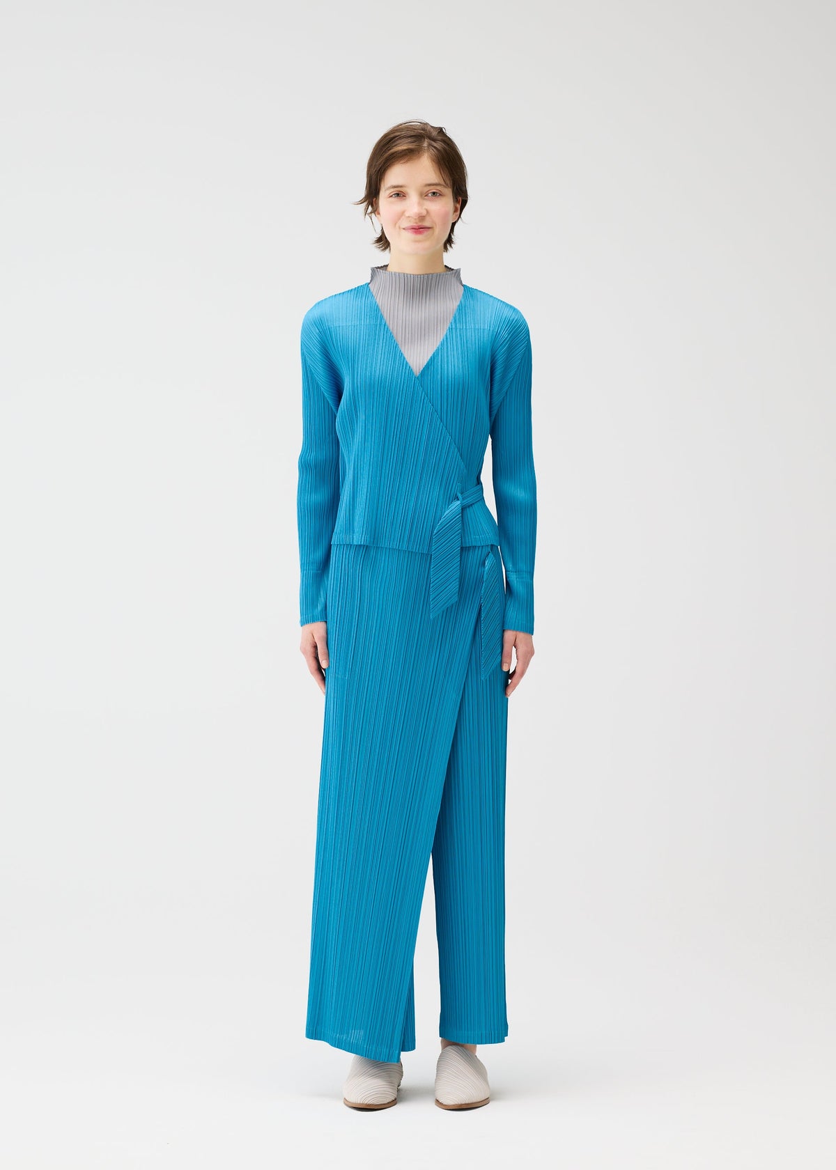 A model wears the PLEATS PLEASE ISSEY MIYAKE FACADE cardigan.