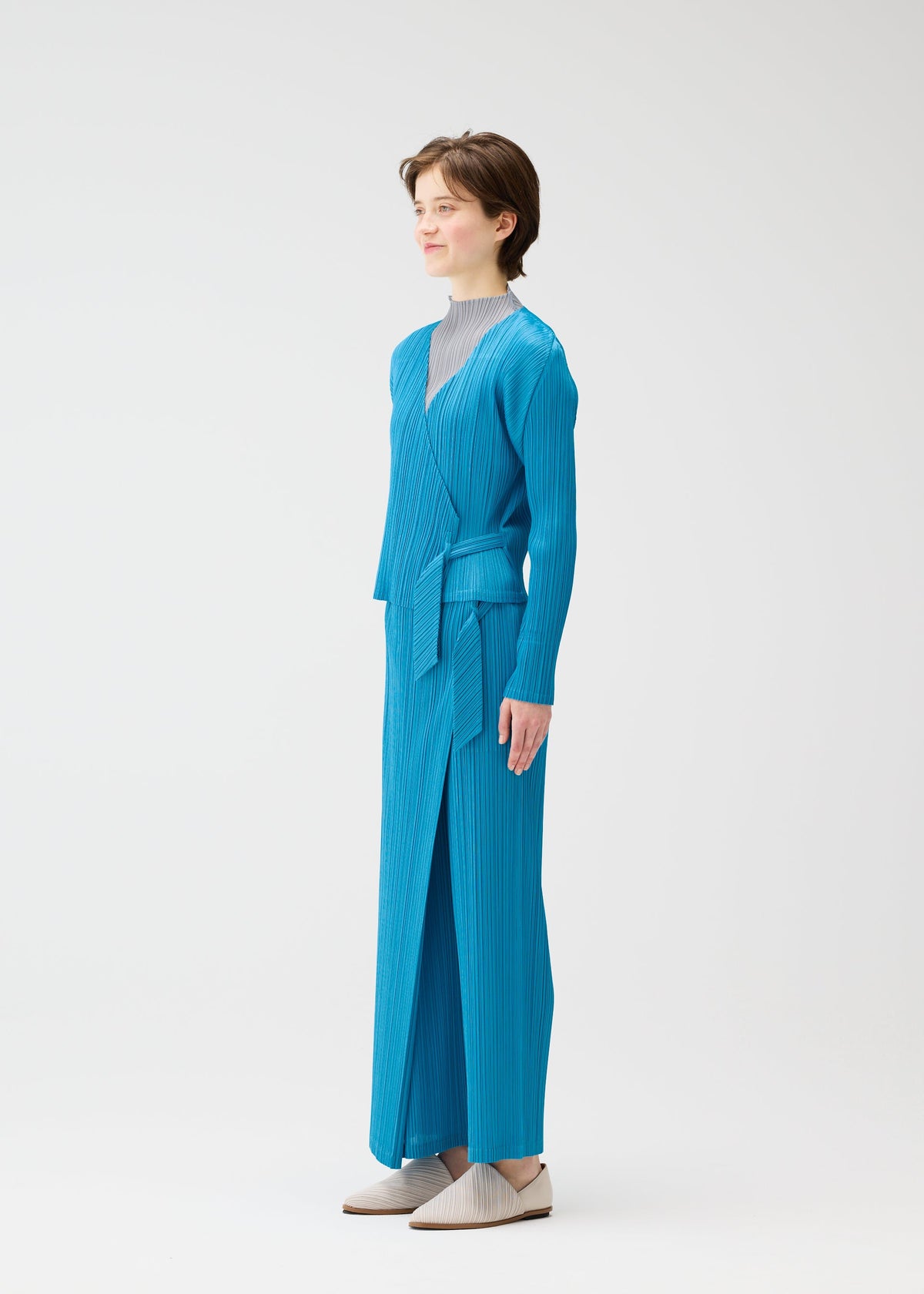A model wears the PLEATS PLEASE ISSEY MIYAKE FACADE cardigan.