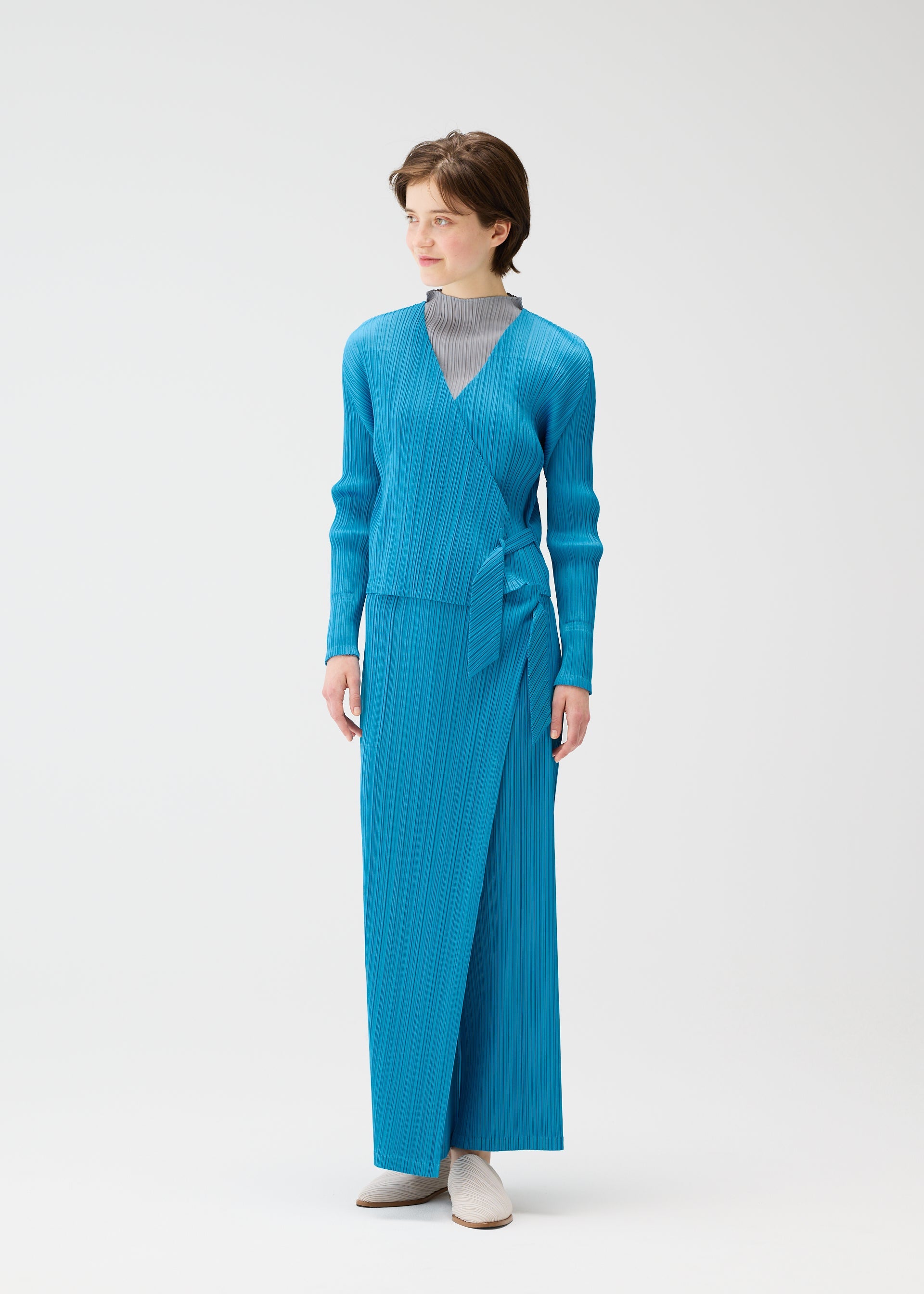 A model wears the PLEATS PLEASE ISSEY MIYAKE FACADE cardigan.