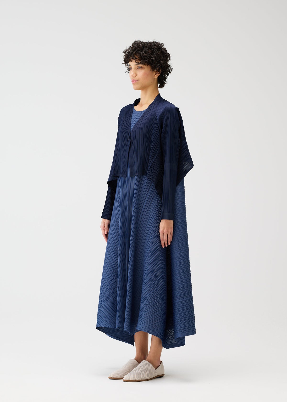 A model wears the PLEATS PLEASE ISSEY MIYAKE CITY FRAME cardigan.