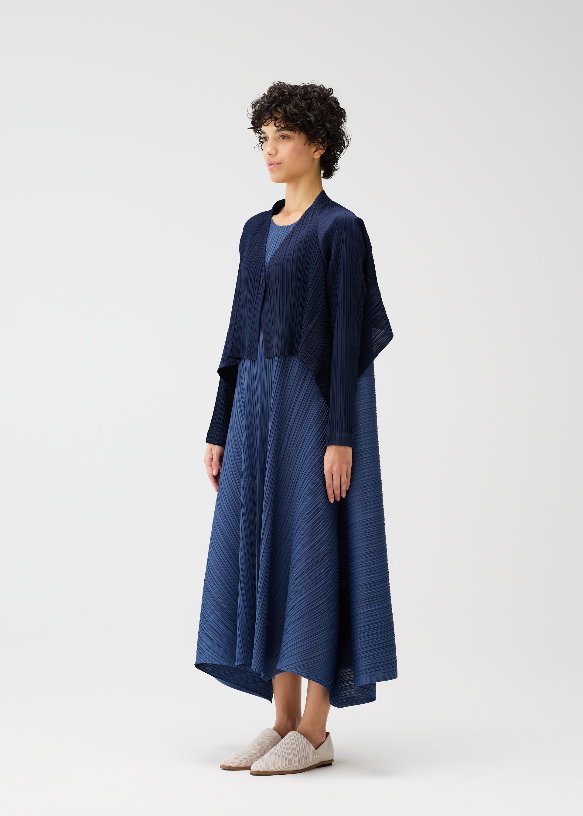 A model wears the PLEATS PLEASE ISSEY MIYAKE CITY FRAME cardigan.