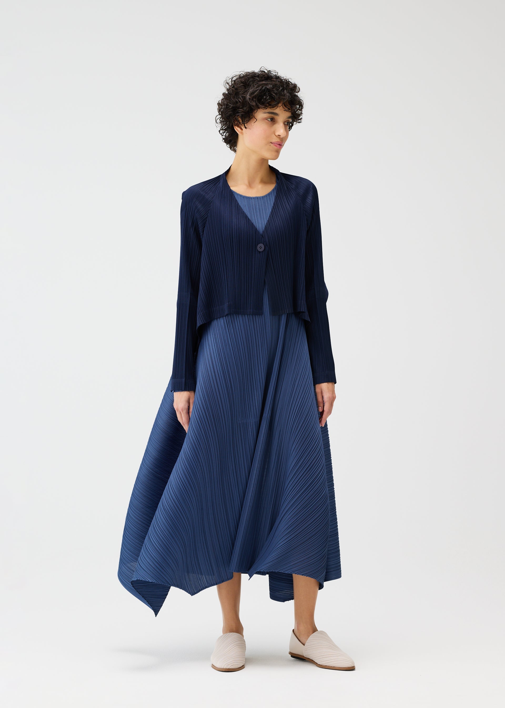A model wears the PLEATS PLEASE ISSEY MIYAKE CITY FRAME cardigan.