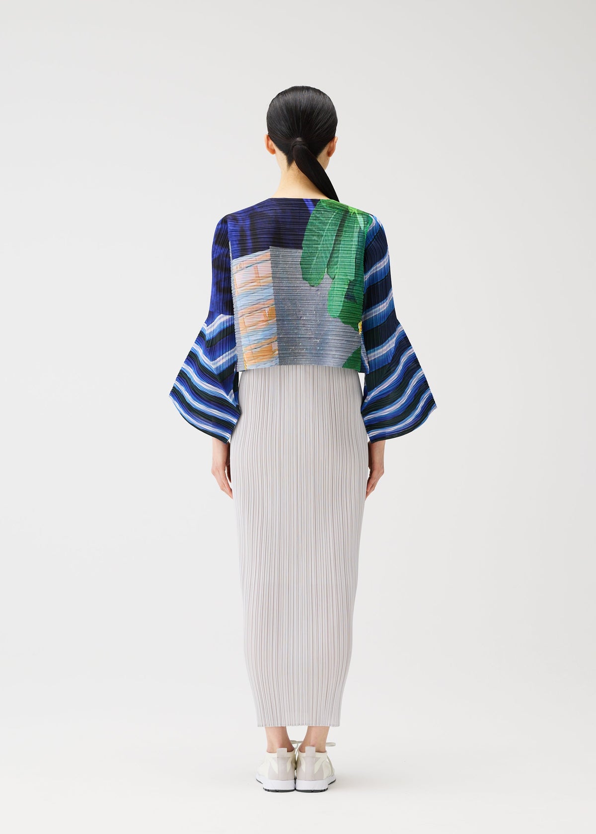A model wears the PLEATS PLEASE ISSEY MIYAKE CITY COLLAGE clothing.