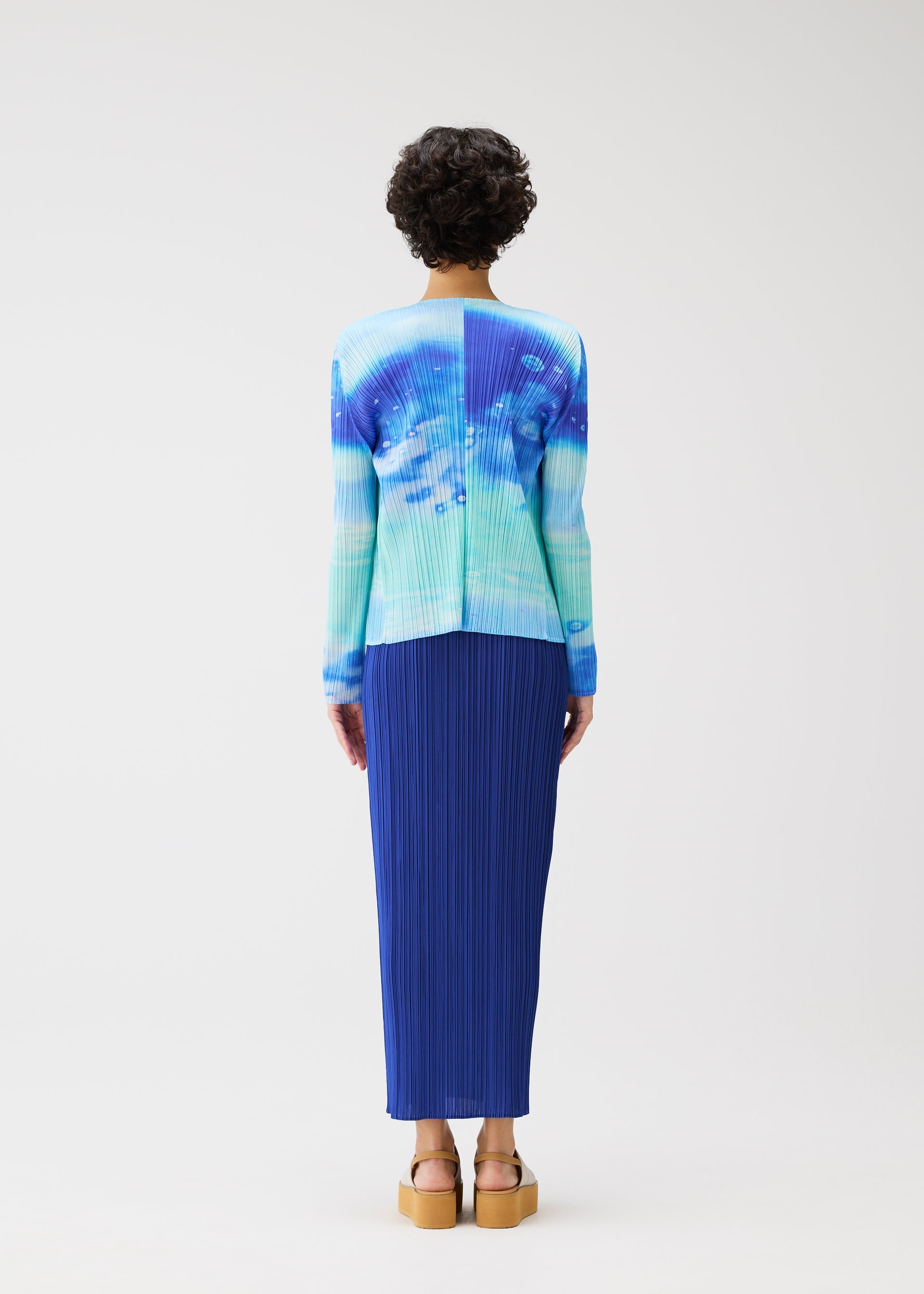 A model wears the PLEATS PLEASE ISSEY MIYAKE SEA BUBBLE cardigan.