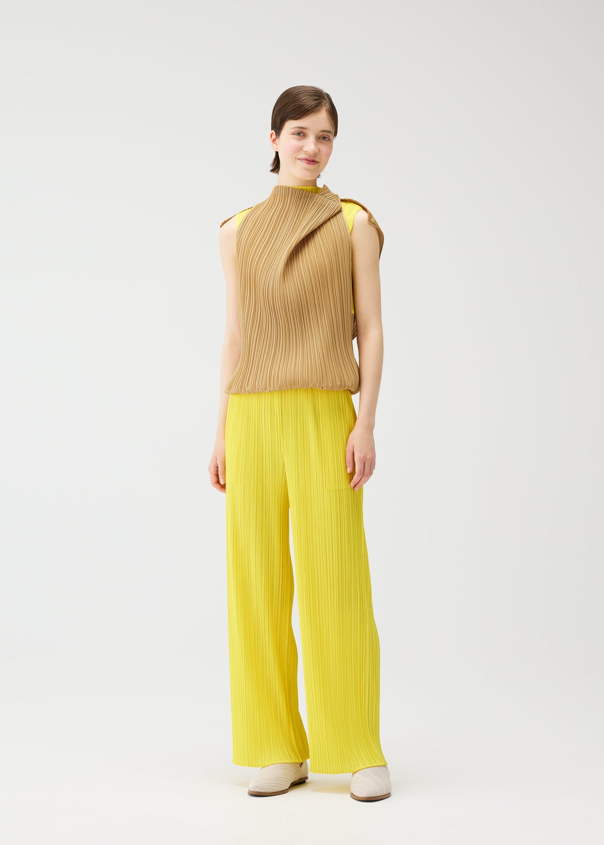 A model wears the PLEATS PLEASE ISSEY MIYAKE SWING dress.