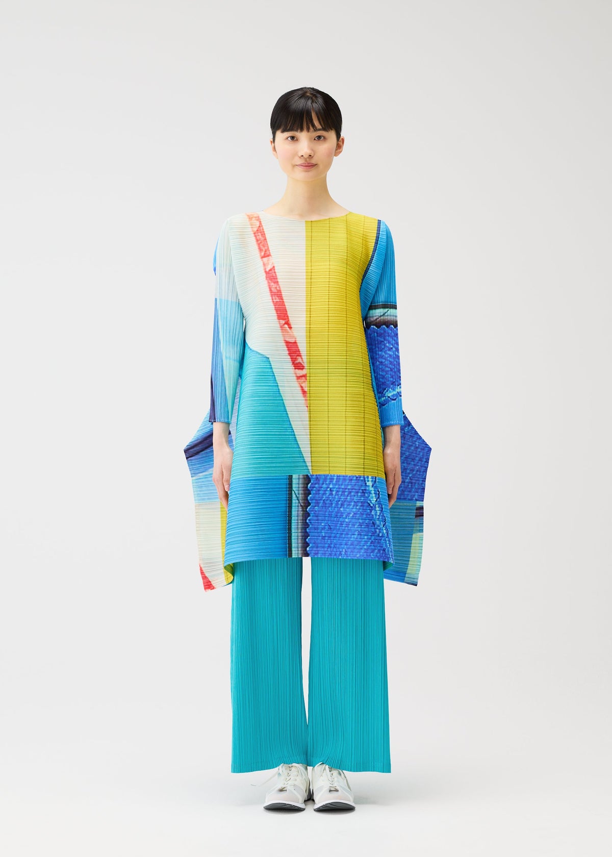 A model wears the PLEATS PLEASE ISSEY MIYAKE CITY COLLAGE clothing.