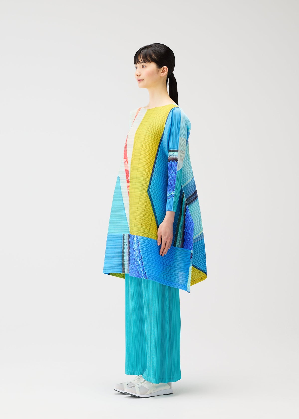 A model wears the PLEATS PLEASE ISSEY MIYAKE CITY COLLAGE clothing.