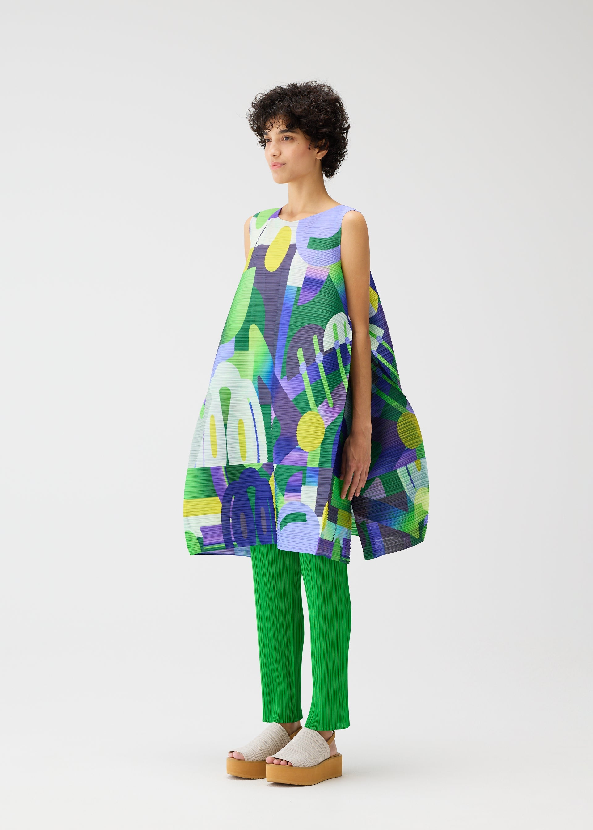 A model wears the PLEATS PLEASE ISSEY MIYAKE PLAYGROUND dress.