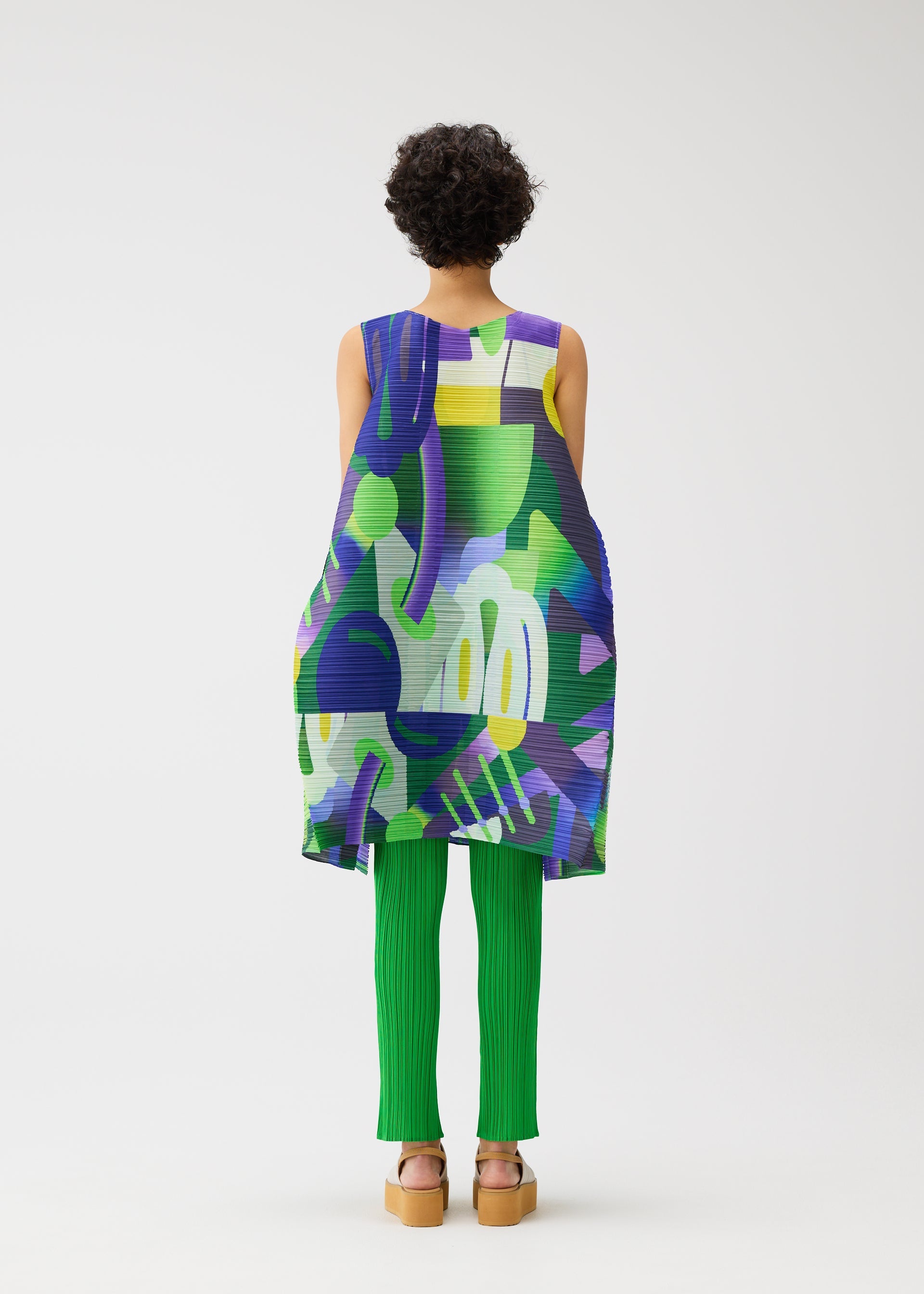 A model wears the PLEATS PLEASE ISSEY MIYAKE PLAYGROUND dress.