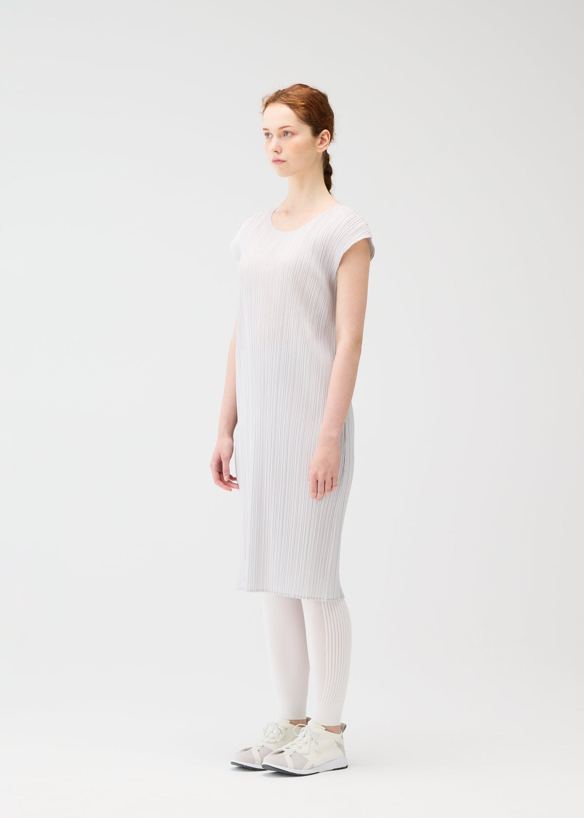 A model wears the PLEATS PLEASE ISSEY MIYAKE A POC SKIN trousers.