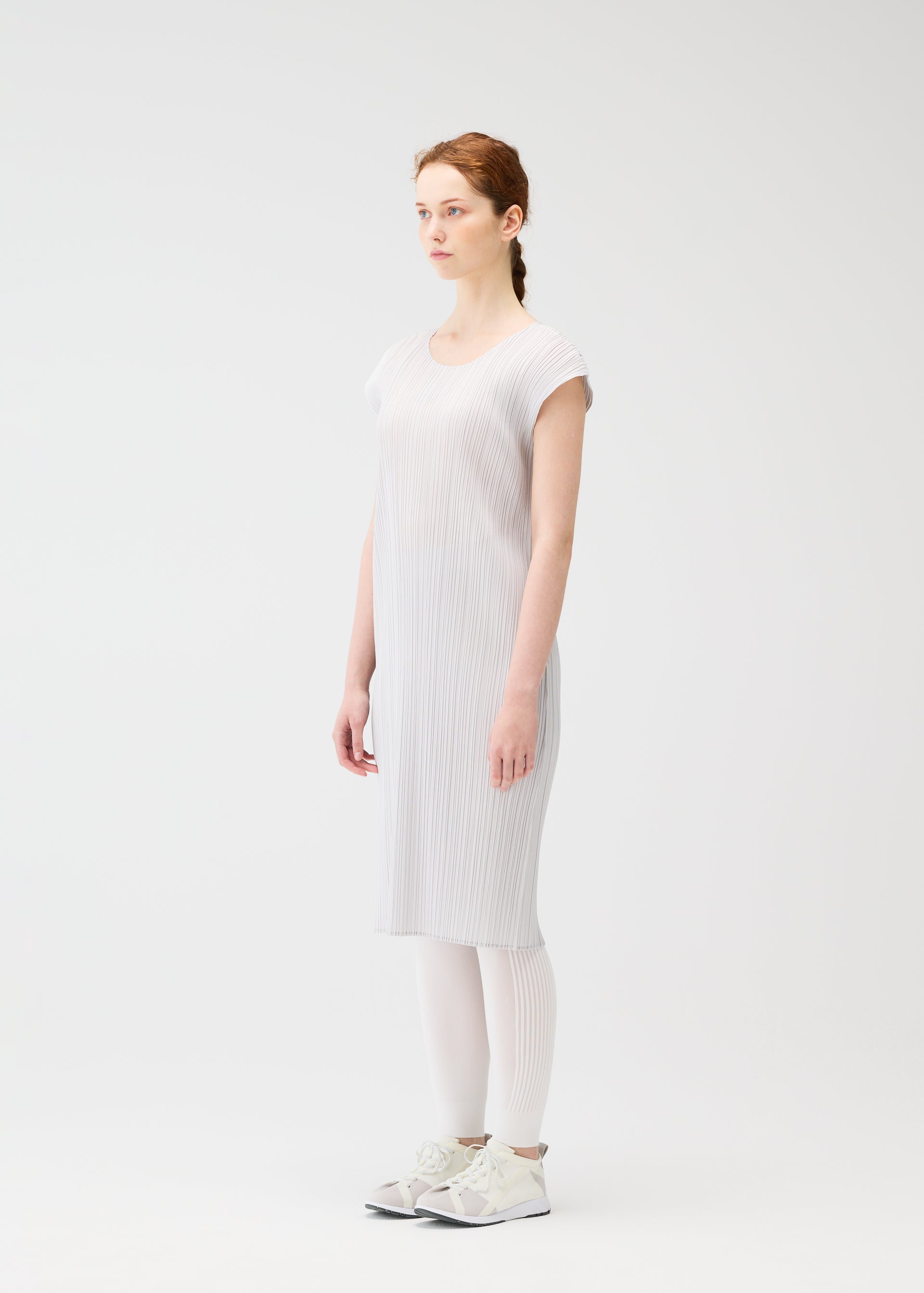 A model wears the PLEATS PLEASE ISSEY MIYAKE A POC SKIN trousers.