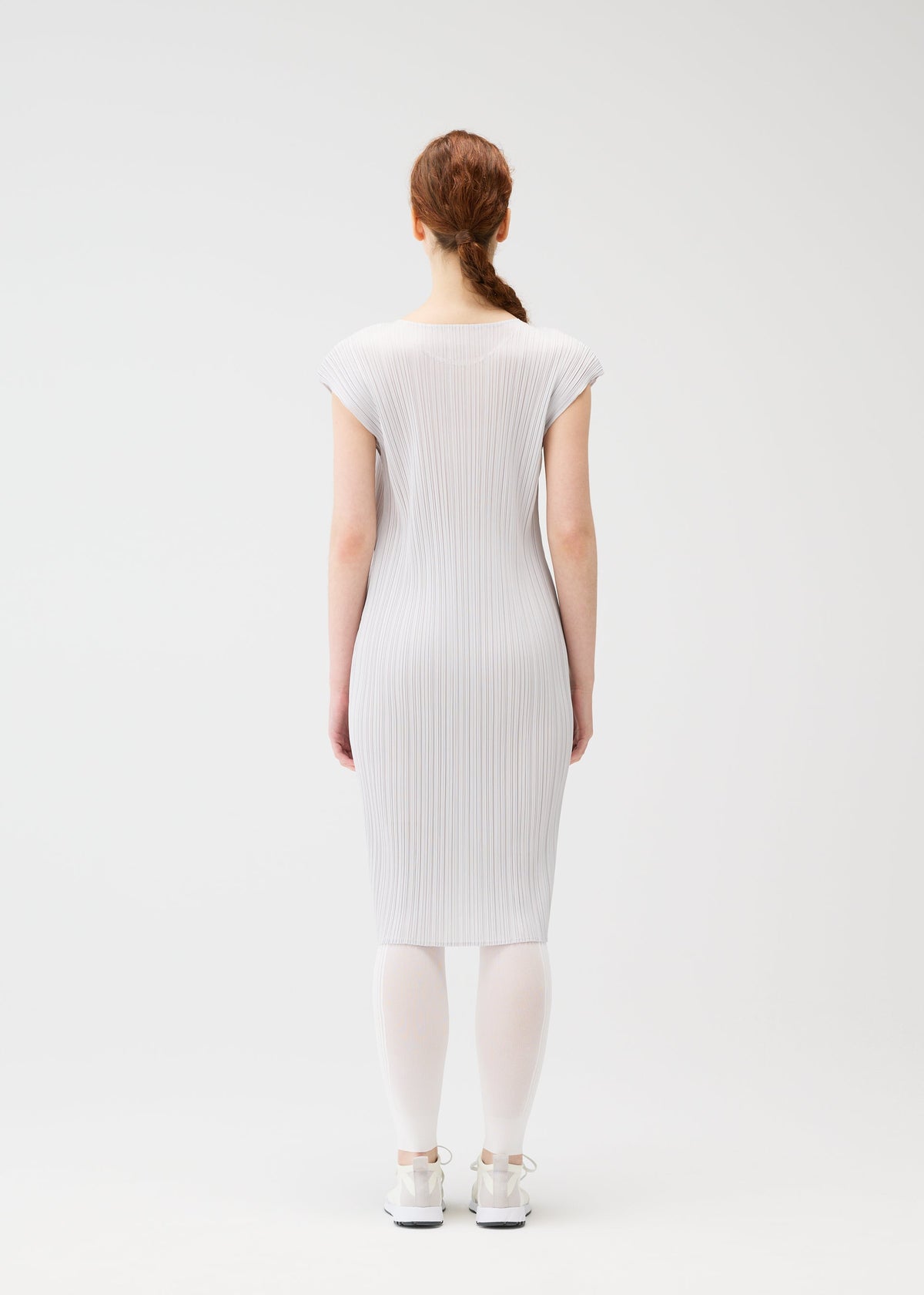 A model wears the PLEATS PLEASE ISSEY MIYAKE A POC SKIN trousers.