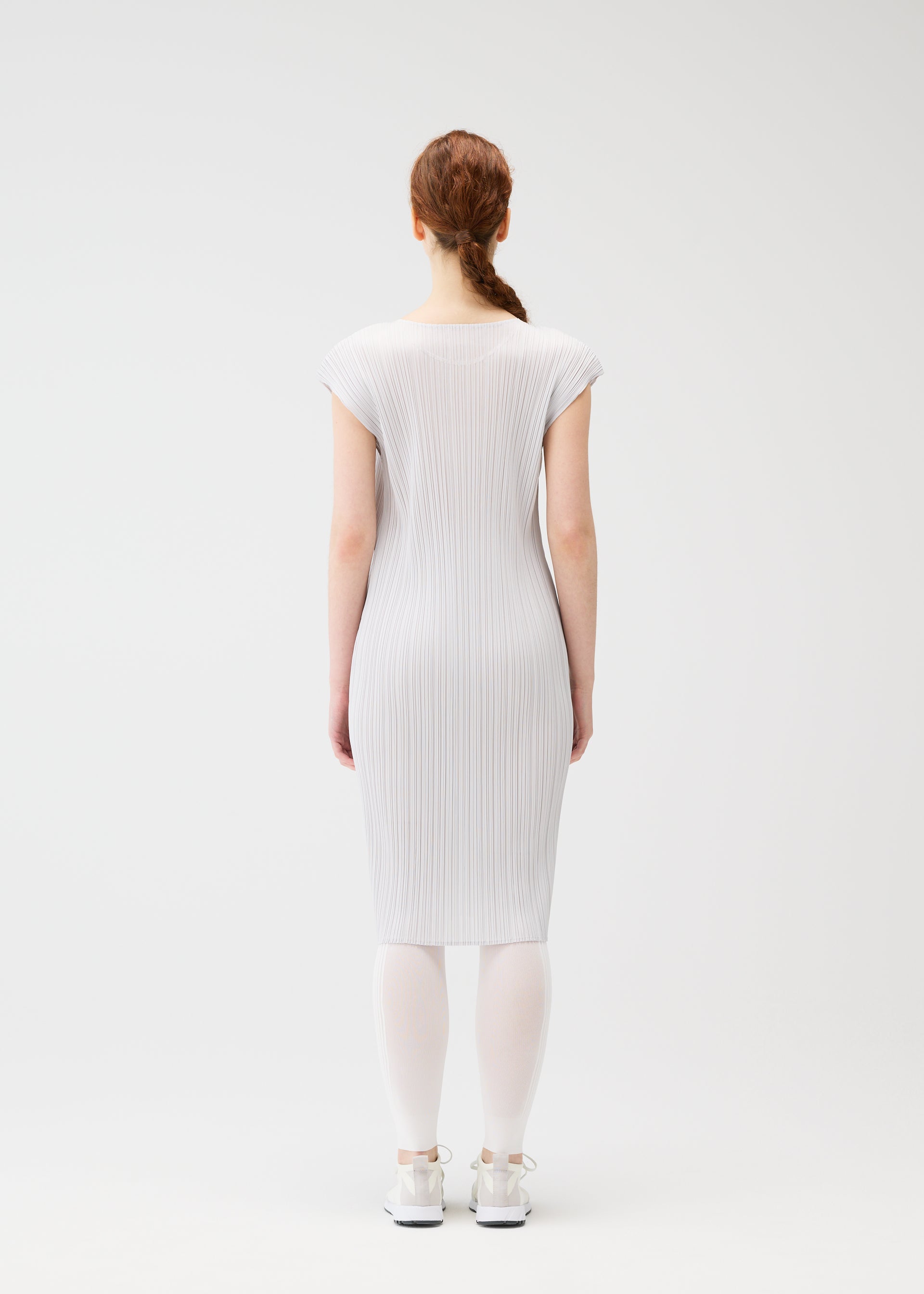A model wears the PLEATS PLEASE ISSEY MIYAKE A POC SKIN trousers.