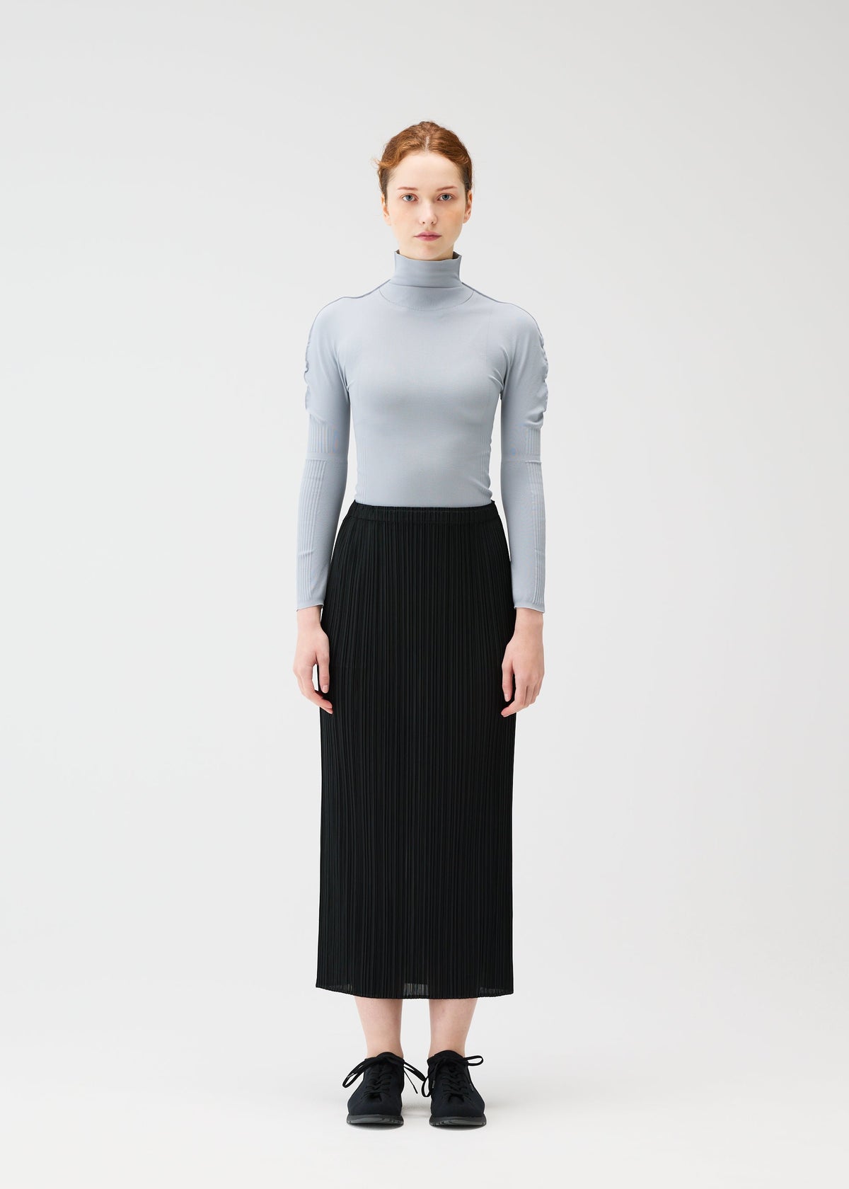 A model wears the PLEATS PLEASE ISSEY MIYAKE A POC SKIN shirt.