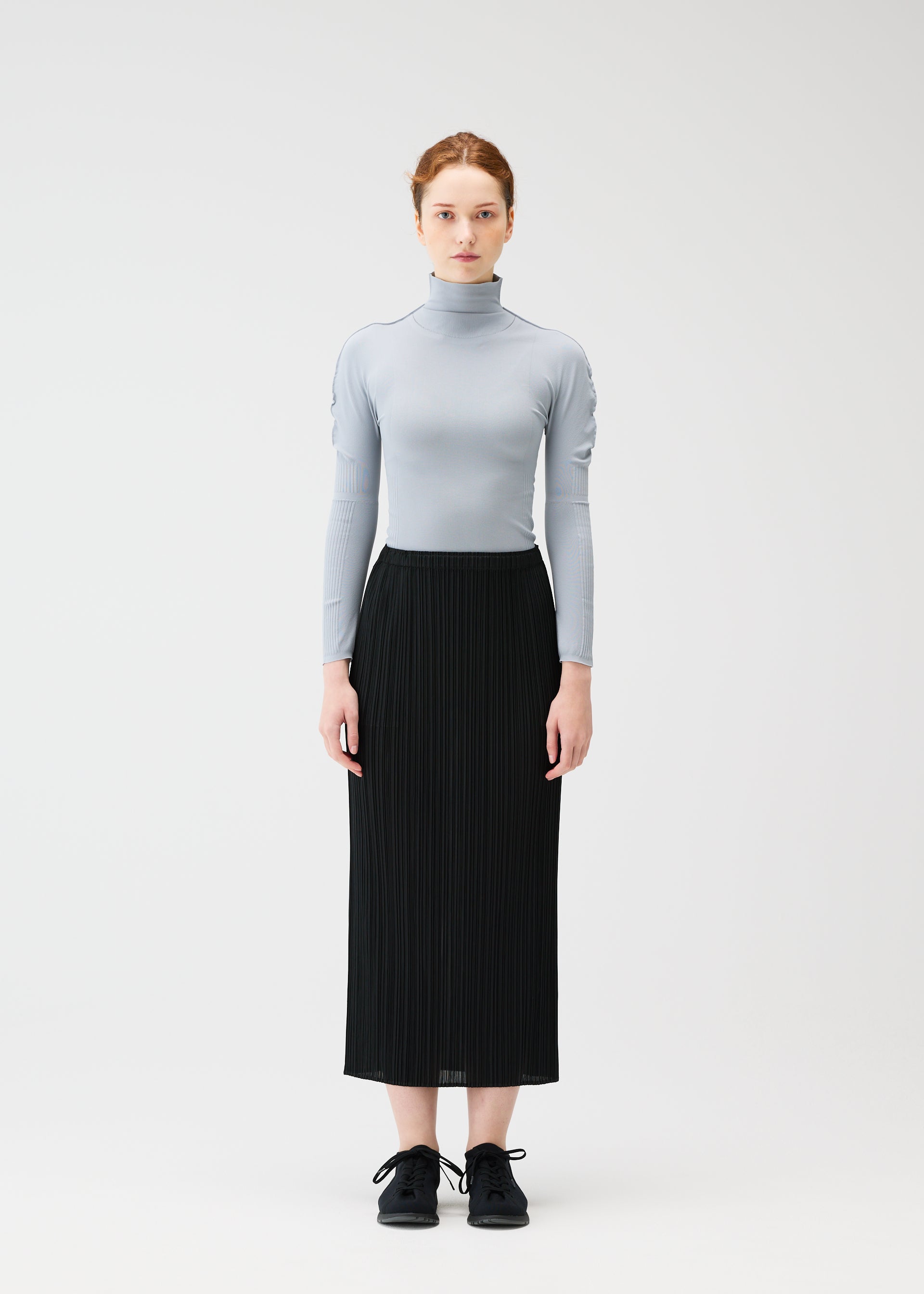 A model wears the PLEATS PLEASE ISSEY MIYAKE A POC SKIN shirt.