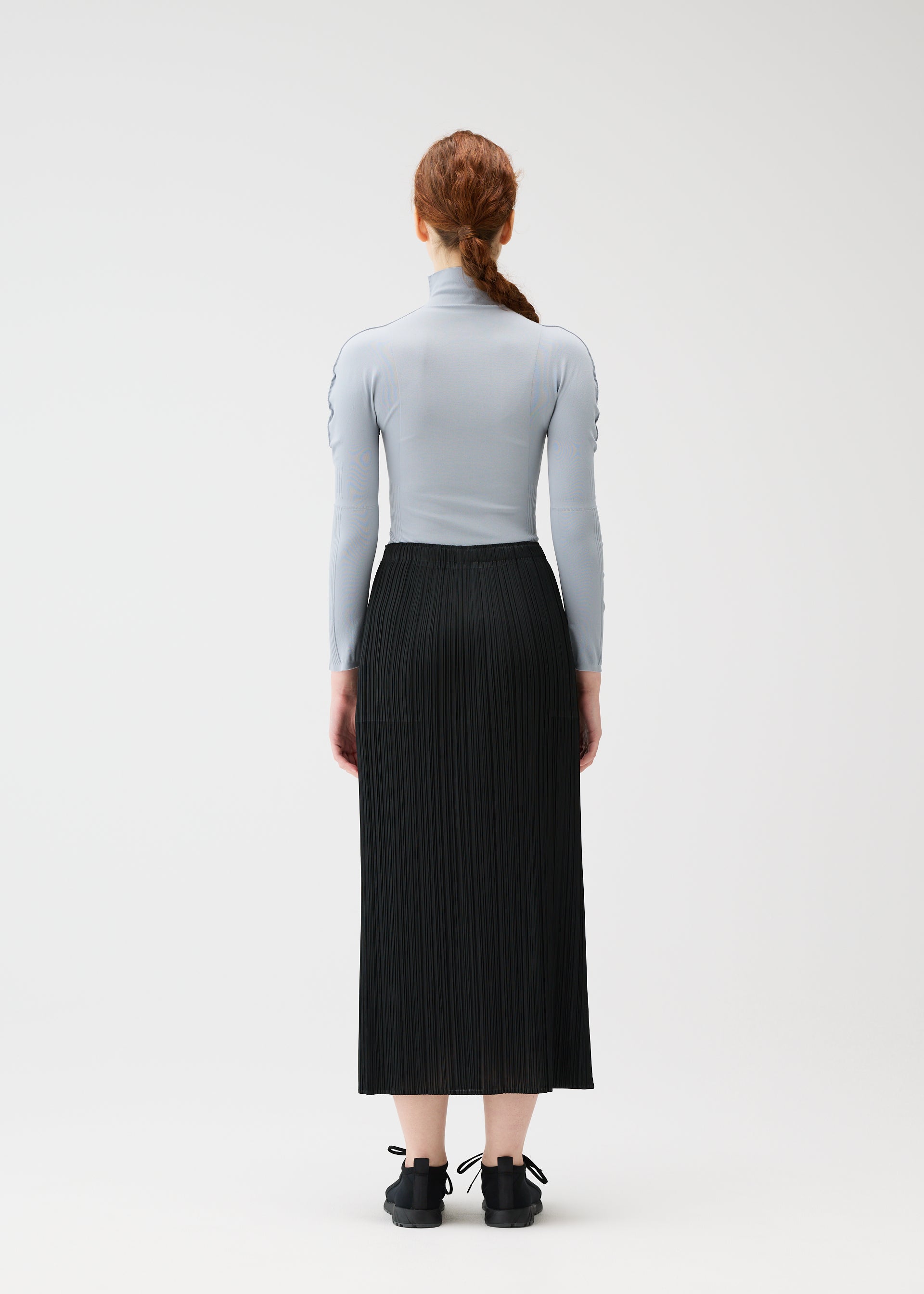 A model wears the PLEATS PLEASE ISSEY MIYAKE A POC SKIN shirt.
