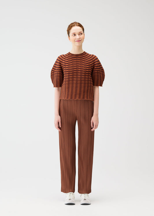 A model wears the PLEATS PLEASE ISSEY MIYAKE COLORFUL MUSHROOM KNIT shirt.