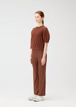 A model wears the PLEATS PLEASE ISSEY MIYAKE COLORFUL MUSHROOM KNIT shirt.