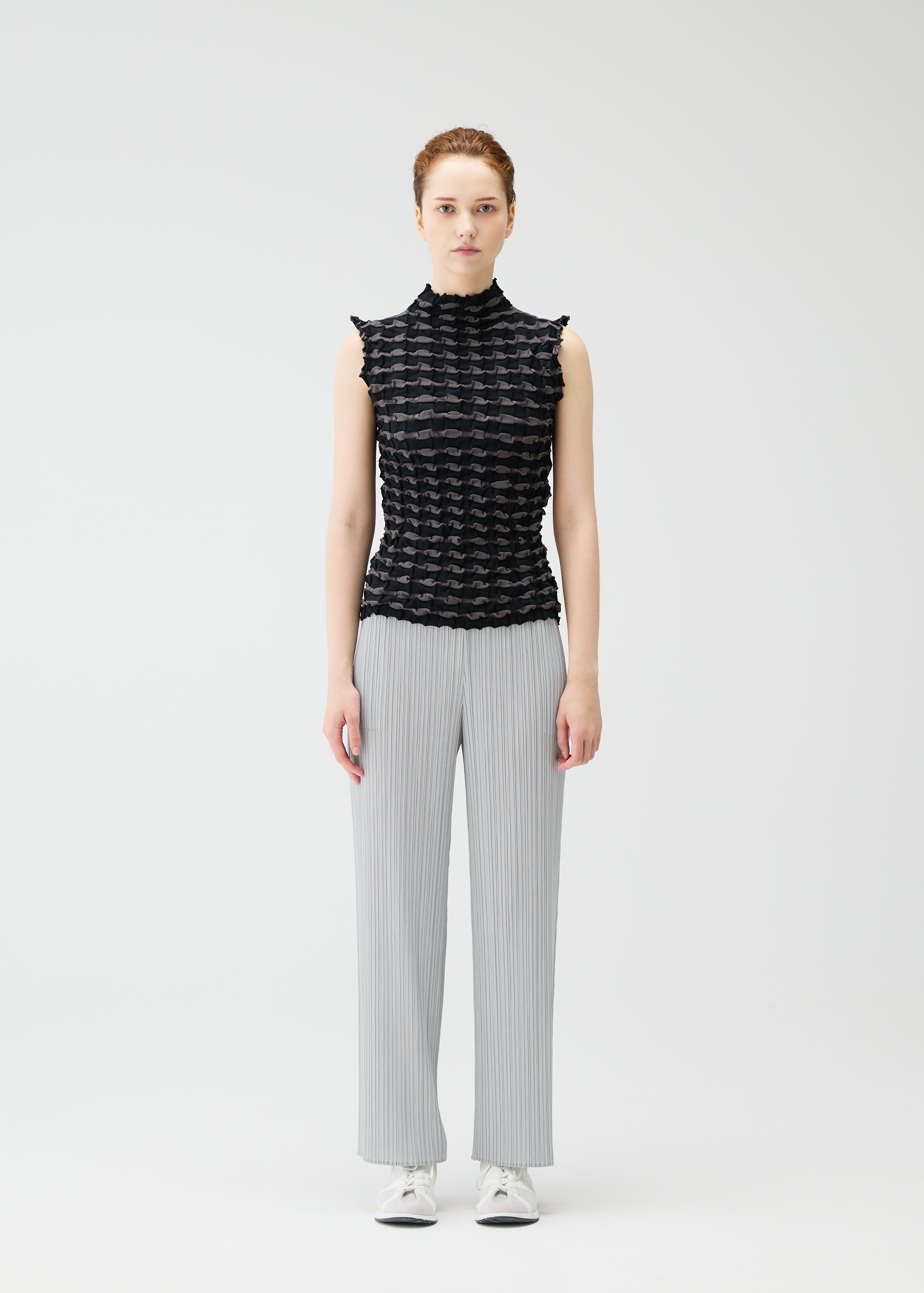 A model wears the PLEATS PLEASE ISSEY MIYAKE TWIST KNIT shirt.