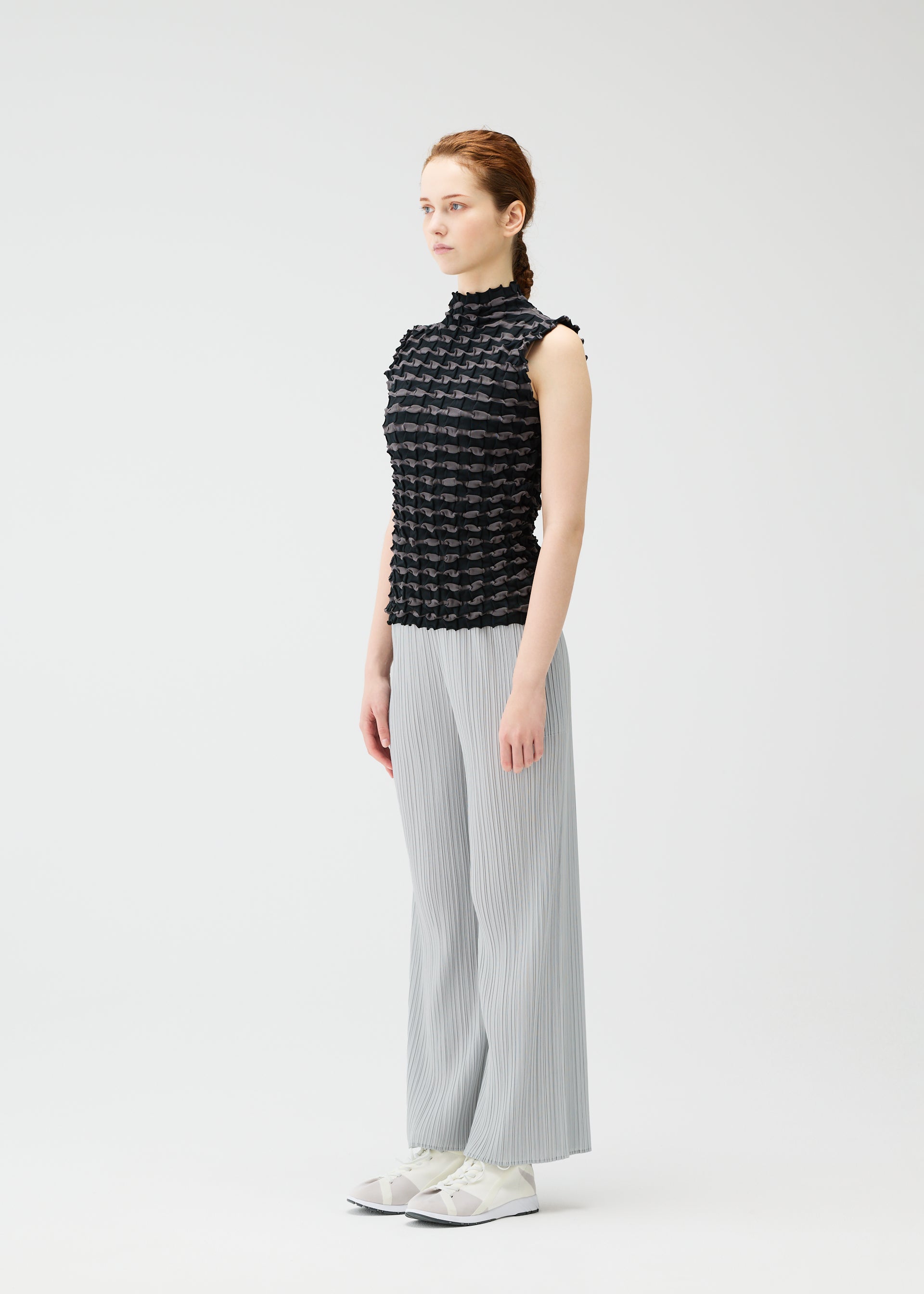 A model wears the PLEATS PLEASE ISSEY MIYAKE TWIST KNIT shirt.