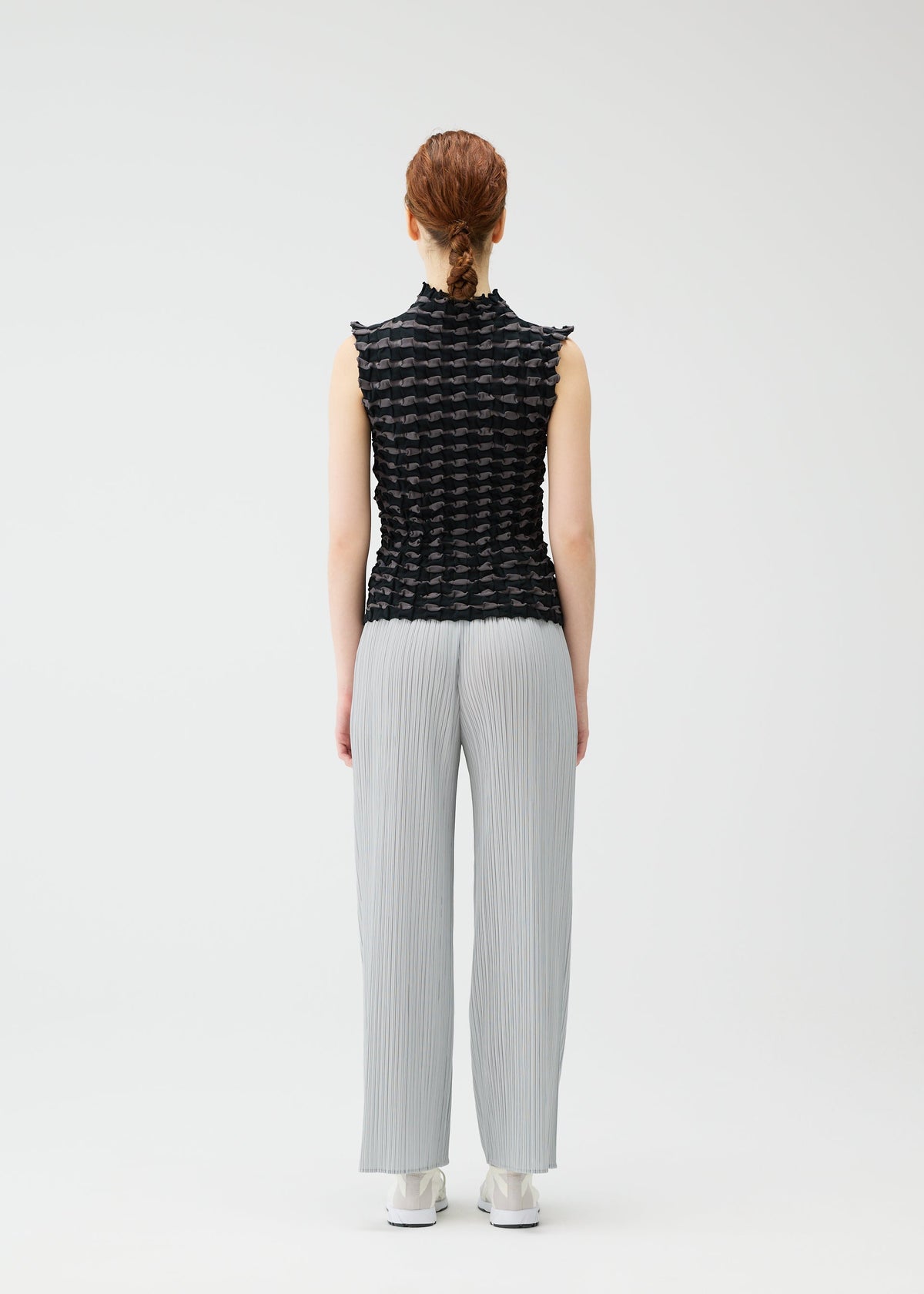A model wears the PLEATS PLEASE ISSEY MIYAKE TWIST KNIT shirt.