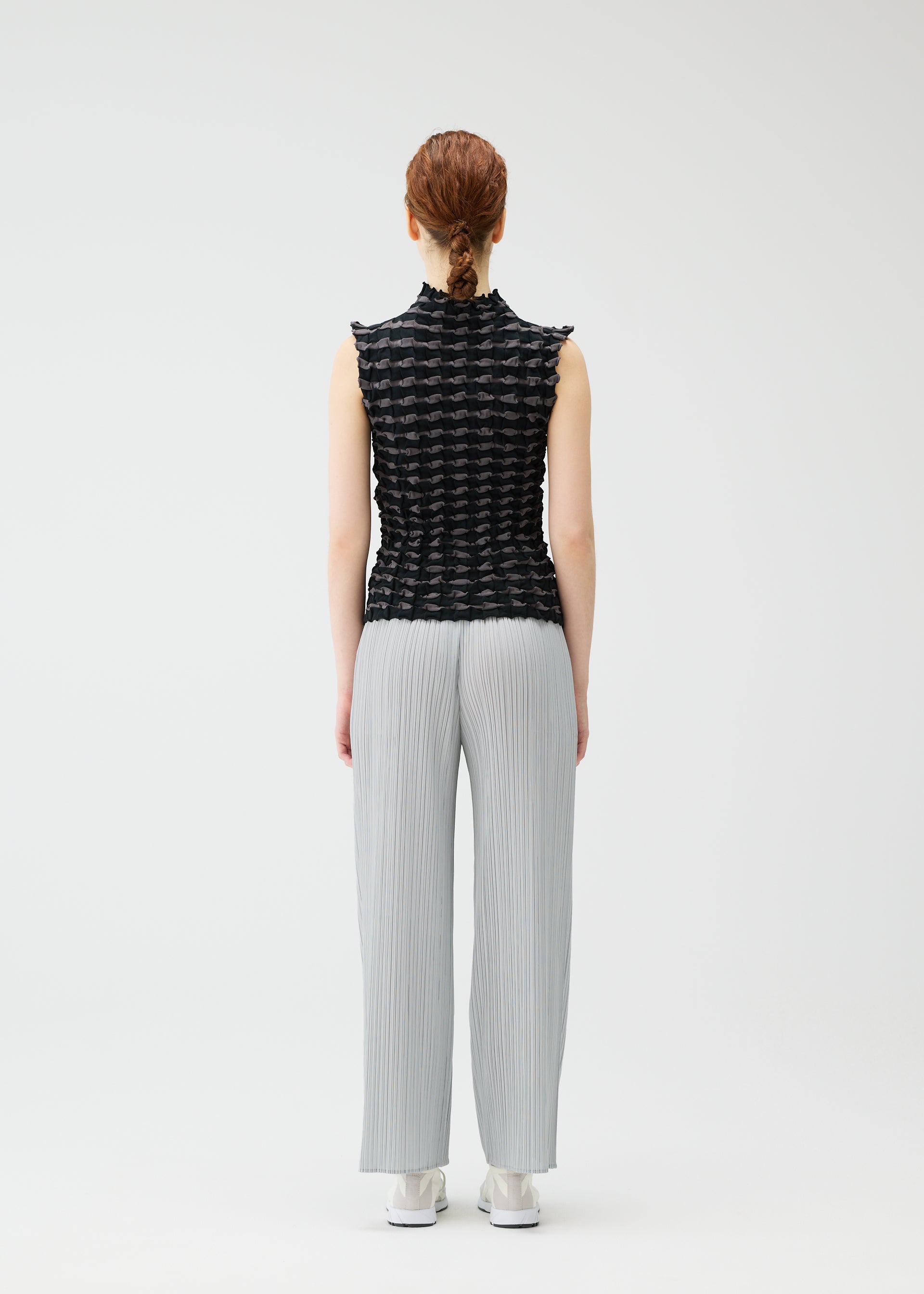 A model wears the PLEATS PLEASE ISSEY MIYAKE TWIST KNIT shirt.