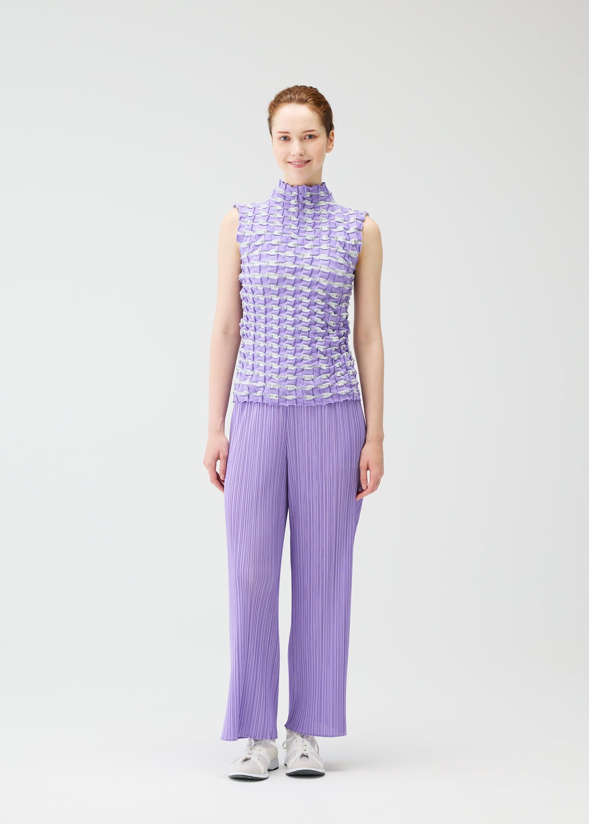 A model wears the PLEATS PLEASE ISSEY MIYAKE TWIST KNIT shirt.